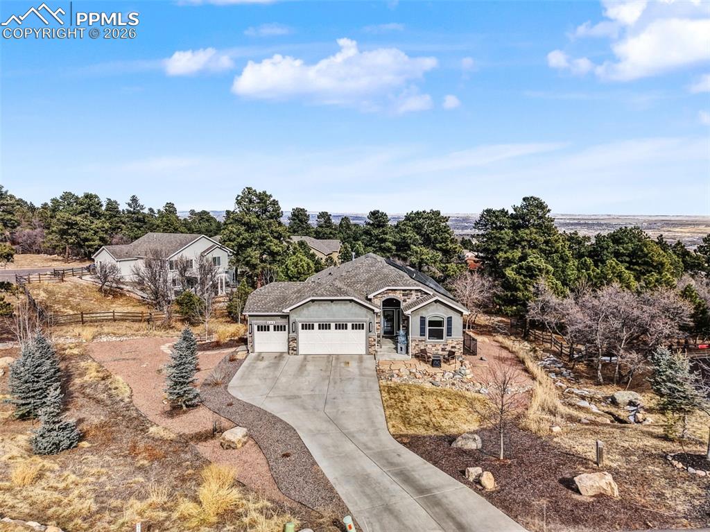 Beautifully positioned on a spacious 0.51-acre lot in the gated Star Ranch community, this newer ranch-style home offers stunning mountain views, mature trees, and a private, park-like setting. Located in award-winning Cheyenne Mountain School District 12, the property combines privacy with convenient access to Fort Carson, shopping, dining, downtown Colorado Springs, and Cheyenne Mountain State Park.The open main-level floor plan is designed for easy living and entertaining, featuring a bright great room with a gas fireplace, hardwood flooring, and large windows that frame the scenic surroundings. The gourmet kitchen includes a large island, solid-surface countertops, stainless steel appliances, double ovens, warming drawer, and a sunny dining nook with walk-out access to the backyard and patio. A formal dining room adds flexibility for hosting.The main level offers a spacious primary suite with a spa-like five-piece bath and walk-in closet, along with a second bedroom suite. The finished walk-out lower level provides a generous family and game room with a full wet bar and beverage refrigerator, plus two additional bedrooms, each with access to full bathrooms.This home features a high-capacity, solar system that powers two electric vehicles. It can supply energy to the entire home for up to three days in the event of a power outage.The system includes a city approved battery bank. With peak-hour electricity rates rising, this solar setup keeps your costs stable and your home running efficiently. Outdoor living is a highlight, with extensive landscaping, a full-length lower patio, upper composite deck, and a raised flagstone fire pit—ideal for entertaining or relaxing while enjoying the views. Additional features include central air conditioning, a three-car attached garage, main-level laundry, and thoughtful designer finishes throughout. This is a rare opportunity to own a newer, move-in-ready home on one of the premier lots in Star Ranch.