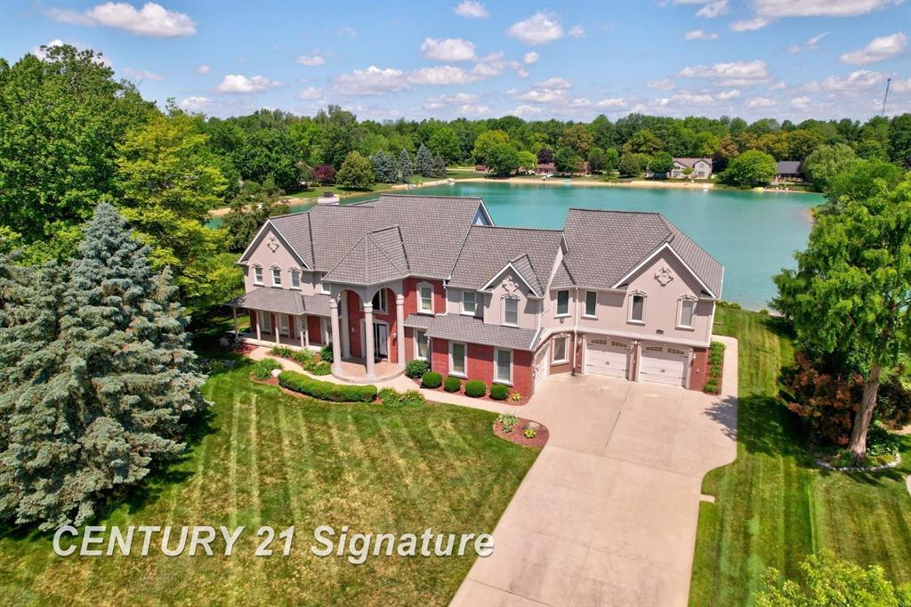 Discover unparalleled elegance in this grand lake front residence offering over 6,800 total square feet of living space with four en suite bedrooms and seven baths. The home was COMPLETELY REDESIGNED AND REBUILT IN 2007, with a 4000 sq ft. NEW STRUCTURE, electricity, plumbing and heating. There is a bedroom located on the first floor for ease and convenience, perfect for guests or family, the primary bedroom is located on the second floor and includes a sitting area, fireplace and wet bar; and is also adjacent to the library/den. Bedroom three and four, also located on the second floor, have gorgeous views of the lake and an additional second home office. Soaring 18' ceilings and floor to ceiling windows are just a few of the high end features. Others include, Schonbek crystal chandeliers, custom cabinetry, marble and fine wood flooring, custom bathroom fixtures, smart home technology, whole house generator, an Olympic size inground pool with automatic cover, outdoor kitchen, an 11x11 pergola and 5,616 sq ft of stamped concrete patio. The lower level offers an exercise room, theatre area, dance floor and game room.  This is truly a home that will surpass any of your expectations and can provide you the lifestyle you have always wanted.  Meticulously maintained and updated.