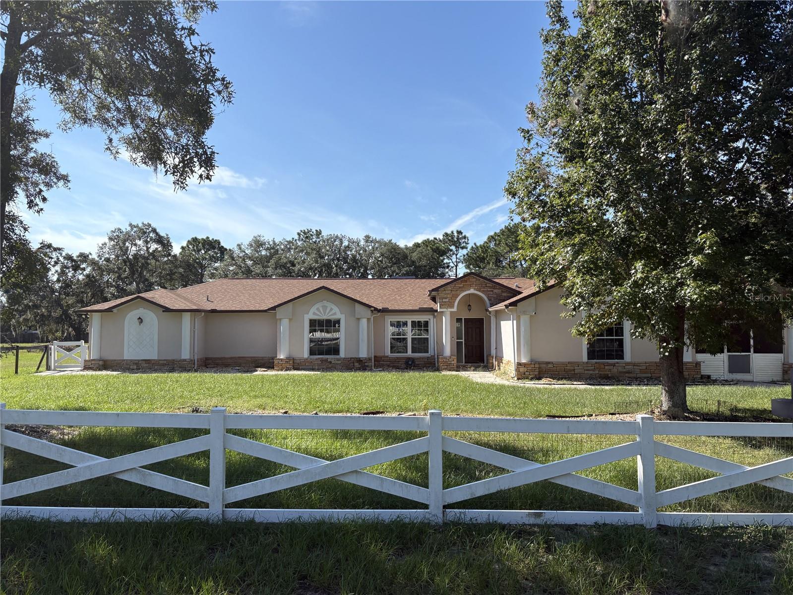 Price just reduced. Welcome to this spacious 2,564 sq. ft. home located in the highly sought-after Oakwood Acres community, offering the perfect blend of space, comfort and country living. The home features 4 bedrooms, 3 full bathrooms, a large bonus/flex room, an attached 3-car garage, and a 576 sq. ft. detached garage/workshop-perfect for storage, hobbies, vintage cars, motorcycles or boat, with a carport to boot! Inside, you'll find an updated kitchen, complete with appliances, granite countertop, and a large island that opens to the family room, making it perfect for entertaining or everyday living. This cozy living area includes a wood-burning fireplace, adding warmth and charm. The ensuite bathroom has a spacious ADA accessible bathroom with dual vanity sinks and a large, open shower, a separate HVAC, thermostat, and water heater, as well as a private entry door that opens to the large, spacious 2.5 acre cleared, flat yard. Outside you will find a large, partly covered, screened in patio with plenty of space for entertaining. This home also comes with a fully wired-in propane Generac Generator, providing your comfort and security during hurricane season. Only minutes to the Suncoast Expressway with a straight shot to Tampa/Tampa Airport to the south and restaurants, medical facilities, and shopping to the north.