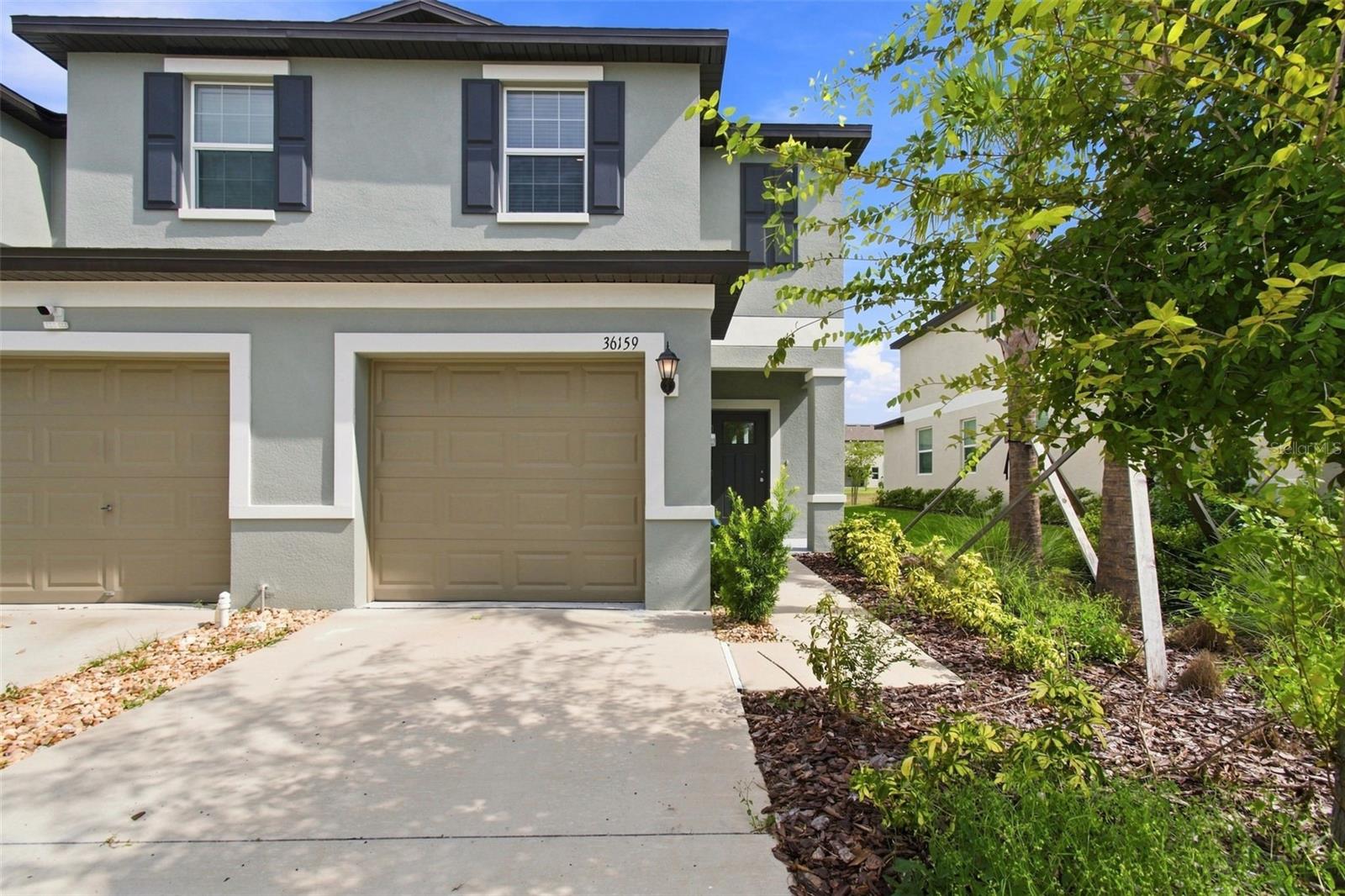 NEVER LIVED IN FORMER BUILDER MODEL with a POND VIEW! Located in the Zephyrhills community of Townes at Windsong, this END-UNIT Glenmoor floor plan offers 2 bedrooms, 2.5 baths, an UPSTAIRS LOFT and attached 1-car garage, along with the added benefit of a COMMUNITY POOL. The bright, open first floor brings the kitchen, dining and living areas together in one comfortable gathering space, with tile flooring throughout and a distinctive accent wall adding a touch of the model home's original designer detail. The kitchen features crisp shaker-style cabinetry, generous counter space, stainless steel appliances, a pantry and a breakfast bar overlooking the main living area. Sliding glass doors draw your eye toward the POND VIEW just beyond the backyard, creating a peaceful backdrop from the kitchen and dining area. A convenient half bath completes the first floor. Upstairs, the versatile LOFT provides valuable additional living space that can easily function as a home office, media area, reading space or second living room. The spacious primary suite includes a WALK-IN CLOSET and private bath with DUAL SINKS and an oversized walk-in shower. The secondary bedroom and additional full bath provide a comfortable arrangement for guests, while decorative wall molding adds another distinctive model-home detail upstairs. Enjoy low-maintenance townhome living with access to the COMMUNITY POOL and a convenient Zephyrhills location with easy access to shopping, dining, medical services and major roadways connecting to Wesley Chapel, Tampa and surrounding areas. With its NEVER-LIVED-IN condition, END-UNIT location, POND VIEW, flexible loft and community amenities, this former model offers an exceptional opportunity to own a move-in-ready home without the wait for new construction.
