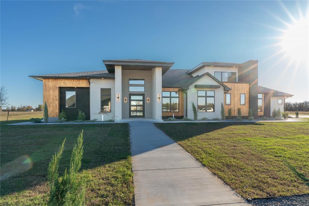 Modern opulence meets exceptional craftsmanship in this one-of-a-kind estate behind the gates of The Ranch at Lost Creek. Situated on 0.85 acre, the property offers 4,823 square feet of combined livable space between the 3,607-square-foot main residence and impressive pool house/shop. Inside, sophisticated design is paired with uncompromising finishes: premium Marvin windows and doors, a dramatic 5-foot iron pivot entry, white oak and maple cabinetry, Constantino quartz, designer lighting and flooring, and a Monogram appliance suite. The home offers 3 bedrooms, 3.5 baths, private office and a fully custom theater with recessed floor and a raised bar. The primary suite is a private retreat of exceptional scale and finish, with dual shower fixtures, integrated quartz sinks and expansive his-and-hers closets. Resort-style outdoor living is equally remarkable, featuring a full outdoor kitchen, Powerfold screens, electric heaters, saltwater pool with infinity-edge spa, tiled firepit and fully turfed grounds with a 3-hole putting green. The 60x40 pool house and/or shop mirrors the aesthetic of the main residence, with approximately 1,200 square feet of additional living space, full bath, kitchenette, bar, laundry, and 12-foot glass slider, plus a climate-controlled shop space with oversized 14-foot RV/camper and 10-foot boat/car doors. Prewired for a golf simulator or theater, car lift and whole-home generator, the property also includes an above-ground safe room, climate-controlled 4-car garage, whole-home water filtration and softener, tankless water heater, EV charging, full foam insulation, private well and septic, irrigation and extensive drainage. A truly rare offering where modern luxury, thoughtful engineering and extraordinary versatility come together in one of West Norman’s most distinctive properties.