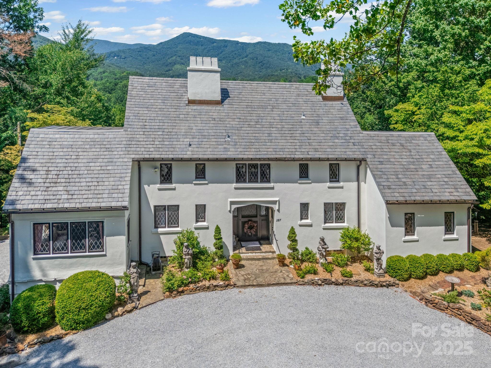 Charming 1920s English Cottage with Breathtaking Mountain View’s. 
Privacy, captivating sunsets, & views. A true gem of historic charm & refined comfort, the home seamlessly blends period elegance with thoughtful modern updates. Inside, you'll discover warm, character-rich interiors filled with original architectural details. The inviting primary suite boasts a fireplace, en-suite bath, & a tranquil sitting room or office. Multiple fireplaces, handcrafted woodwork, & vintage accents throughout create a timeless, storybook ambiance. The cottage is nestled among meticulously landscaped gardens that echo the home’s fairytale appeal. Modern comforts abound: a covered screened patio perfect for year-round enjoyment, a dual-fuel HVAC system, generator, & a security system—all offering peace of mind without compromising the home’s heritage. Surrounded by the natural beauty of the Carolina foothills, the property offers easy access to hiking, horseback riding, & the charming town of Tryon.