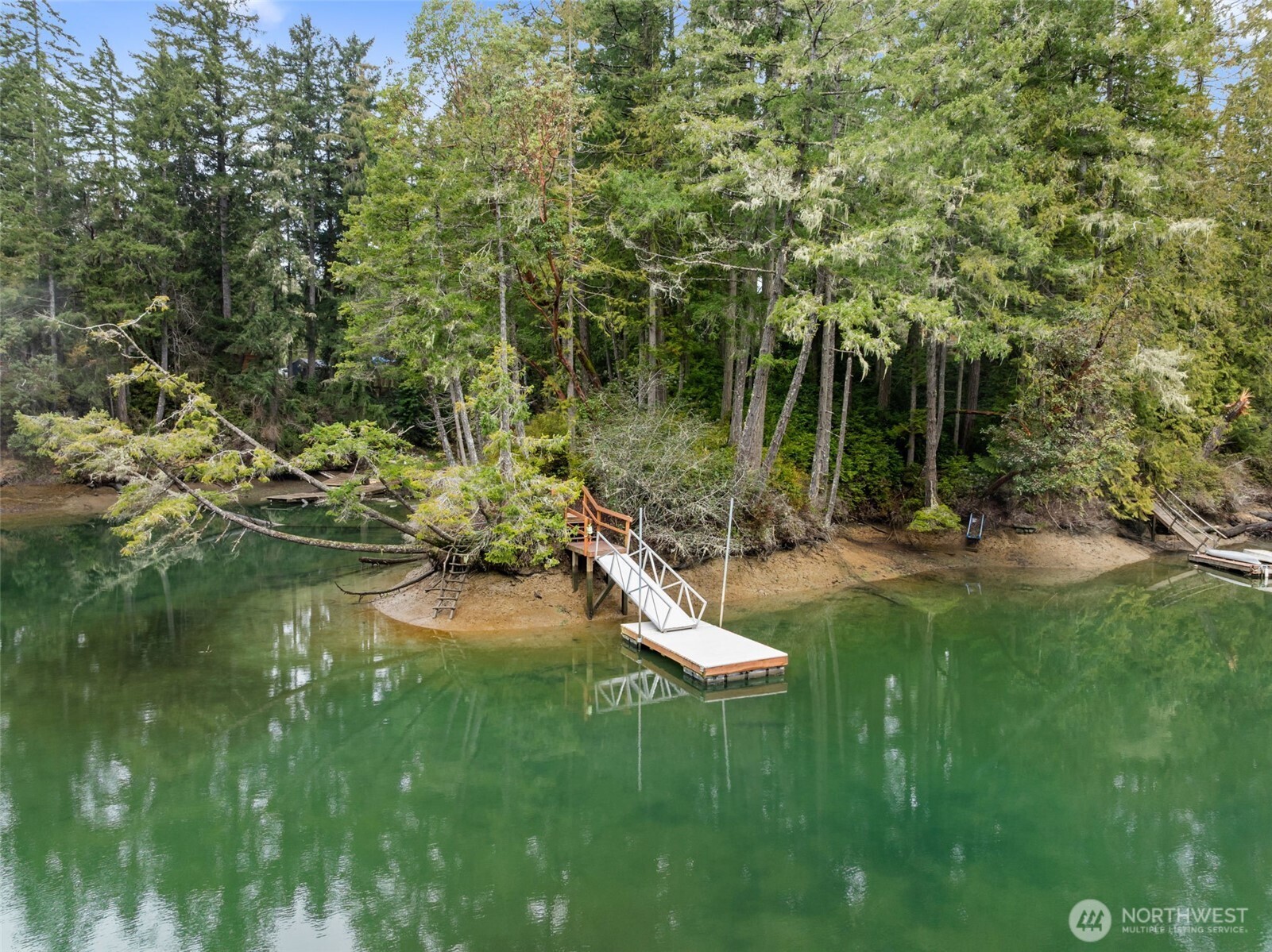Welcome to a rare waterfront retreat in sought-after Boston Harbor offering privacy, seclusion, and direct access to the breathtaking Puget Sound. This beautifully updated 3-bedroom, 1.5-bath home spans 1,228 SQFT sitting on 1.43 serene acres overlooking a peaceful inlet that flows straight into the Sound.  Inside, you’ll find newer hardwood floors, a stylishly updated kitchen with open dining space, stainless steel appliances, and thoughtfully selected fixtures and finishes that create a refined, premium feel throughout. A fully finished separate office provides the perfect work-from-home solution or guest quarters  The detached, fully finished office offers 576 SQFT that could be used as den/game room complete with a full bathroom and ductless heat/air — ideal for guests, hobbies, or multi-generational living.  Step outside and experience the true magic of this property. Enjoy heat pump, expansive deck, private patio, firepit and custom landscaping designed for both entertaining and quiet relaxation. A picturesque trail leads you to your private dock and 100 feet of waterfront, offering instant access to the Sound for boating, kayaking, and unforgettable sunsets.  This is more than a home — it’s a private waterfront lifestyle.
