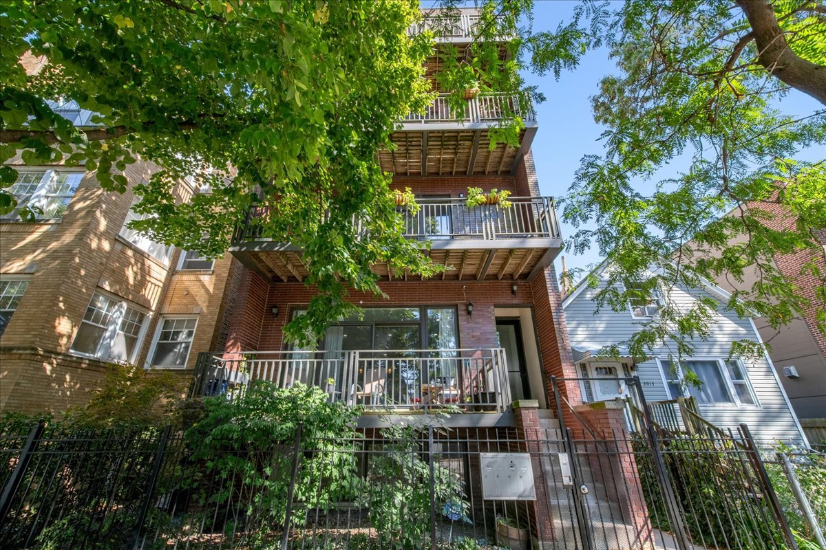 Step into luxury living at 2019 N Whipple St #1, a spacious 22 foot wide 4 bedroom, 3 bath duplex in Logan Square that lives like a single-family home. The main level offers three bedrooms and two baths, highlighted by an expansive open living and dining area with soaring 10' ceilings, hardwood floors, built-in speakers, and a cozy fireplace. The chef's kitchen is a true centerpiece with 54" custom cabinetry, Calacatta quartz countertops, and premium finishes-perfect for both everyday living and entertaining. The luxurious primary suite features a spa-caliber bath with a steam and rain shower, body sprays, built-in bench, and separate soaking tub. Convenient first-floor laundry completes this thoughtfully designed level. The lower level extends the home's functionality with a spacious second living area anchored by another fireplace-an ideal retreat for movie nights, gatherings, or a comfortable lounge space. A fourth bedroom and full bath make this level perfect for guests, a home office, or playroom, providing both privacy and flexibility. Outdoor living includes a large private terrace and access to a shared roof deck with skyline views, while an attached garage offers secure, easy parking. Ideally located between the 606 Trail and Palmer Square Park, and just minutes to the Blue Line, local markets, and acclaimed restaurants, this home combines neighborhood charm with city convenience. Truly a rare find-don't miss the opportunity to make it yours!