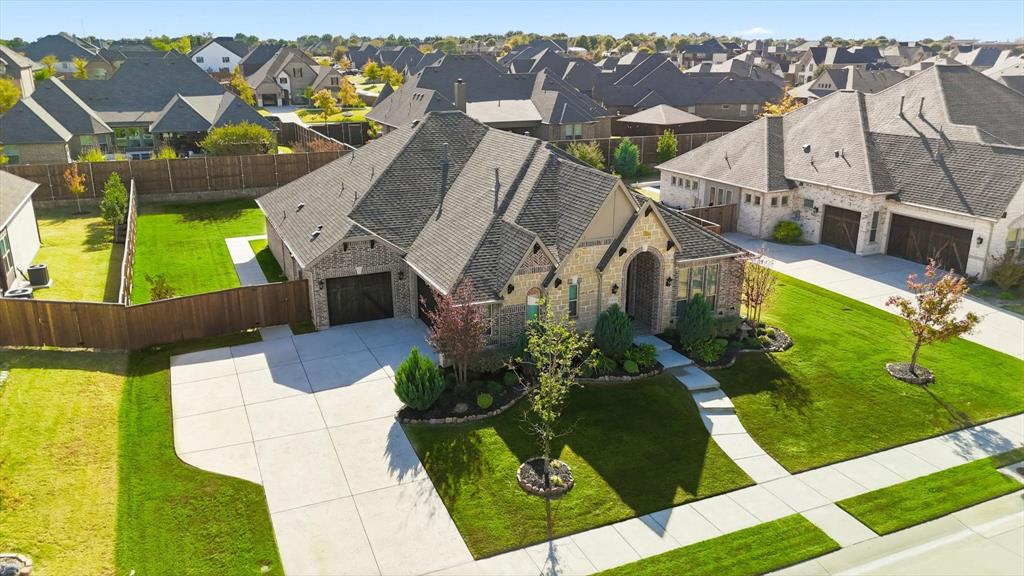 Hard-to-find single story in a quiet, established pocket of Prosper. This north facing home brings in the natural light into every room. Perfectly planned layout, a lifetsyle presence and intuitive thoughtful design for the way people truly live. This Bloomfield home is built on a generous .34-acre lot with backyard privacy and fun at the top of the list. Ready for an anysize pool, playgorund and recreation patios, with additional greenspace for the pets, it checks every box: Oversized dining room for service up to 12, open concept living, smartly separated bedroom wings, and an office tucked behind French doors for those who work from home or want a dedicated space. The design offers high ceilings, thoughtful transitions, and sightlines that keep everything feeling open without losing definition. The living area features dramatic cathedral ceilings and a floor to ceiling stone fireplace as its focal point. Handscraped hardwood floors run throughout the main areas, lending texture and warmth. The kitchen centers the home with a gas cooktop, walk-in pantry, and a large island built to handle everything from prepping dinner to hosting friends. There’s also a large casual breakfast area for quieter meals. The primary suite offers a calm retreat with tray ceilings, natural light, and a spa-like bath designed for function and comfort. Two additional bedrooms sit apart from the main living areas, connected by a private hall—perfect for kids, guests, or multigenerational living. Out back, the extended covered patio is already in place. A true 3-car garage offers space for vehicles, storage, or workshop flexibility. Walking trails surround the neighborhood, making it easy to step outside and enjoy nature without leaving your community. Located in Prosper ISD with quick access to the Tollway and close to major shopping, dining, and conveniences. No stairs, no wasted space—just a home that lives with clarity, comfort, and quiet confidence.