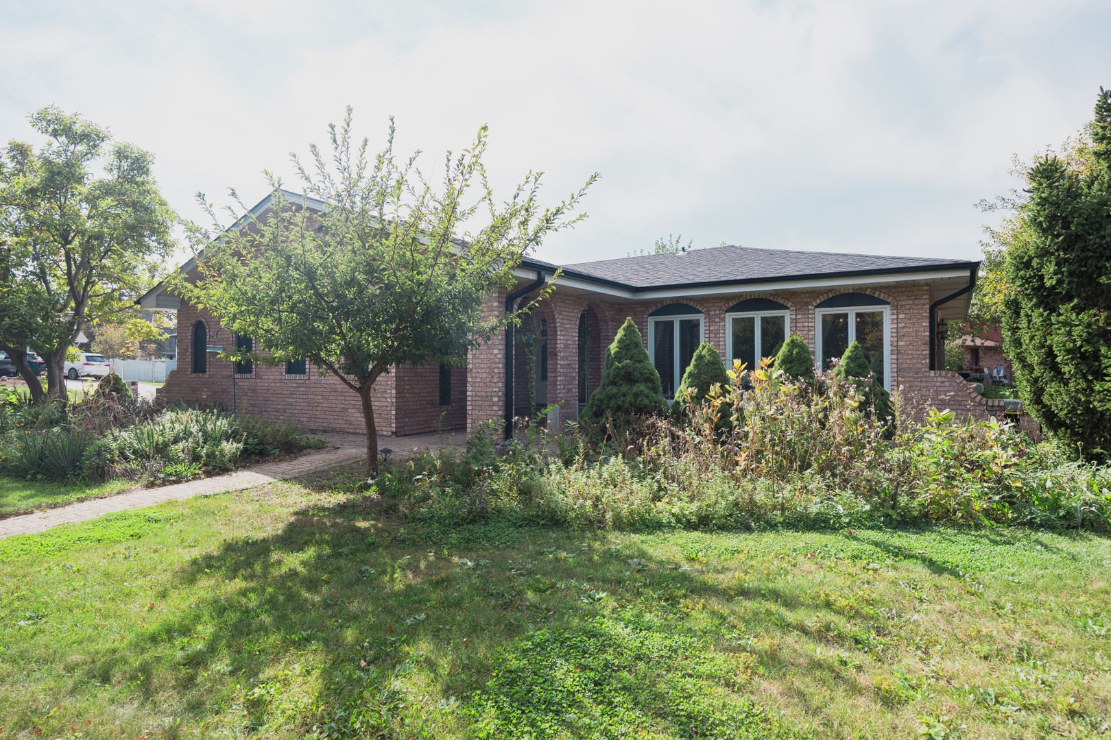 Set on an oversized corner lot, this 3-bedroom, 2.5-bath split-level home offers a versatile layout with room to entertain and relax.  The main level features a formal living room and dining room with hardwood floors and a wall of windows for natural light.  The oversized kitchen offers stainless steel appliances, wood cabinetry, thick granite countertops with beveled edges, room for a 4-person table and opens to the family room with a wood burning fireplace overlooking the patio.  Just a few steps up to the second level are three generous sized bedrooms.  The primary suite includes a private bathroom, 2 closets and a ceiling fan.  The finished lower level includes an open recreation room with space for a home office.  Featured in the laundry room are side-by-side washer and dryer, a sink, floor to ceiling storage, and coffee/bar nook.  Additional storage in the finished crawl space that extends the entire length of the house and in the mechanical room that houses the HVAC and water heater.  Outdoors, enjoy two patios, an edible garden, mature fruit trees, and a greenhouse. An attached 2.5-car garage with driveway completes the property.
