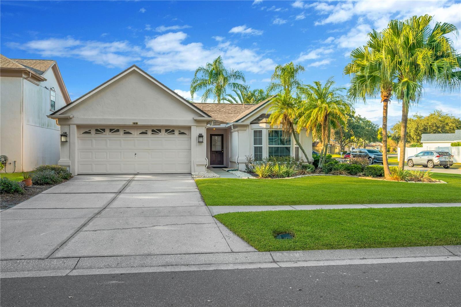 Welcome home to a 3 bedroom 2 bathroom home on a corner lot in Sterling Ranch.  The first thing you notice is the impeccable Florida landscaping.  The grass is well kept, with tastefully done flower beds, and beautiful Palm trees.  The inside of the home has wood floors through all of the bedrooms and living areas.  The primary bedroom is large, has a bay window, walk-in closet, and is on the other side of the home from the other two bedrooms.  The ensuite bathroom has a toilet closet with accessible grab bars, and an accessible curbless shower with grab bars as well. It also comes with dual sink vanities and plenty of counter space.  The living room feels spacious with high ceilings, and two separate sliding glass doors that lead to your patio and backyard.  Standing in the kitchen you can overlook the dining room and living room area.  The kitchen comes with a stainless steel, bottom freezer, French door refrigerator.  There's also a laundry closet with washer and dryer included.  Two major components in the roof (2019) and the HVAC system (2021) have been replaced.  All that's left is for you to add your finishing touches.  The location is great in the heart of Brandon, FL.  You are close to all the shopping and dining you could ask for and the Brandon Exchange (mall) is only 2.5 miles away.  Commuter roads such as I-75 and the crosstown expressway are close and easy to get two.  The community is well kept, and offers a community pool as well.  Call today to schedule your tour of this home.