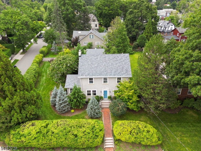 Location, lifestyle & move-in-ready living come together in this beautifully updated & meticulously maintained Upper Montclair home! Offering 4 bedrooms & 2.5 baths, including a lovely primary suite, this home delivers comfort, character & convenience. The 1st floor features a gracious living room with wood-burning fireplace & French doors that spill onto an expansive terraced brick courtyard enveloped in mature landscaping, plus a dining room, family room,  updated kitchen with breakfast area and powder room. Newer windows throughout, central A/C, Generac Generator & a 2-car garage add to the appeal. And the location? Hard to beat! Just 2 blocks to the NYC train, beloved Iris Gardens & Mountainside Park, offering tennis courts, town pool, sport courts & a favorite sledding hill. Also just 2 blocks away, 157+ acre Mills Reservation offers scenic hiking trails, NYC skyline views & an Audubon Hawk Watch. Just 0.4 miles to vibrant Upper Montclair Village, with its fabulous collection of shops, cafes, restaurants, another NYC train station & NYC bus service. A special home in an exceptional location!