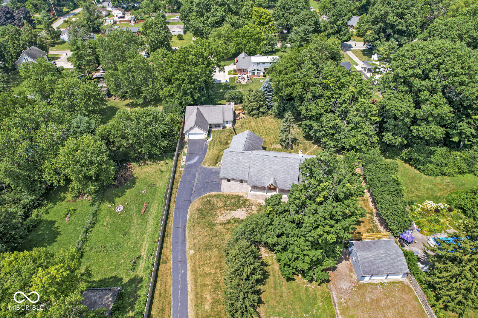 TWO adjacent homes being sold as a package!  Perfect for "in-law" arrangements, multi-generational use, private home and studio use, and/or possible income.   MAIN HOUSE: The all-brick "main house" features approximately 7,000 square feet (per assessor) of living space on the main and walk-out lower levels. An open-concept approach of great proportions rules the main floor. The vaulted ceiling provides a particularly spacious feeling for the great room and kitchen areas, while the dining room and office (possible 5th bedroom?) enjoy generous room sizes. Large sun-filled windows provide great views of the lawns. The walk-out lower level offers four large rooms that have been used as a home theater, game room, family room, and workshop. Another bedroom (with egress) is found here as well. The two-story oversized two-car garage provides a significant amount of "air space" for storing cars, boats, etc. RANCH HOUSE: This all-brick ranch home offers approximately 1600 square feet of flexible living space. Three bedrooms and two full bathrooms! The open-concept great room / kitchen is perfect for entertaining. A lovely deck is just off the great room. The wider interior doors, NO STEP to the attached two car garage, and generous closet space are unexpected features. Although both homes are being sold as a package, each is on its own parcel with a shared driveway. This is a rare opportunity to create your own estate -- perfect for multi-generational family / friends / studio situations! Great location near Garfield Park, Fountain Square, Downtown, and University of Indianapolis. In the city, but feels suburban! Ranch House room sizes and details available in Additional Documents.
