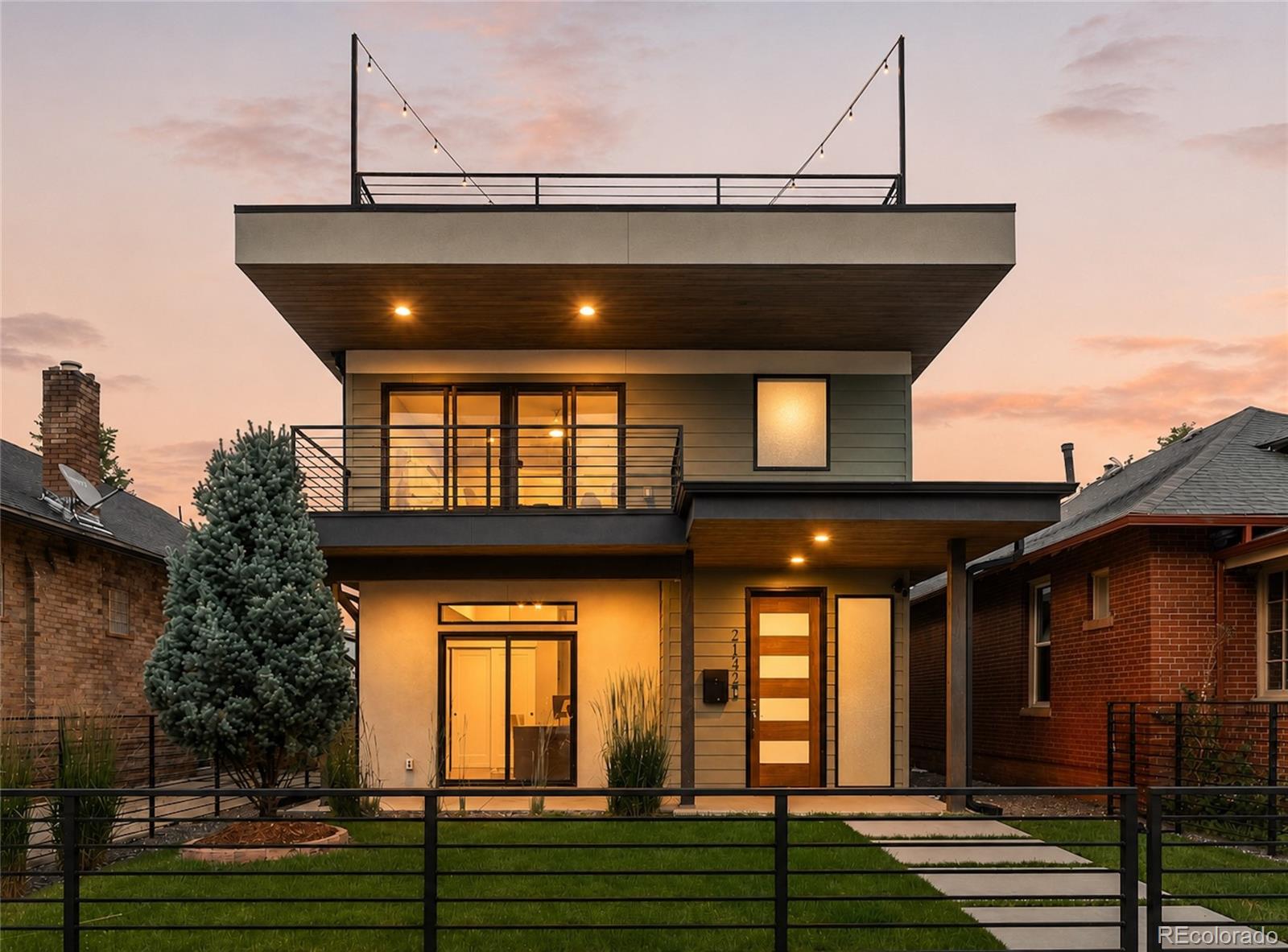 A distinctive modern masterpiece just three blocks from Sloan's Lake, this thoughtfully designed residence pairs striking architecture with warmth, character, and exceptional space. Spanning three levels with six bedrooms, 4 bedrooms + lounge on the same floor, 1,000+ sqft of outdoor living, and a rare three-car garage, the home offers the dream floorplan in one of NW Denver's most sought-after neighborhoods. A glass-enclosed bedroom, ideal as a study, creates a dramatic intro as the main level unfolds into seamless living, dining, and kitchen spaces, anchored by a three-sided fireplace. Nearly 20ft of cabinetry provides exceptional storage, complementing quartz countertops, stainless steel appliances, double ovens, gas range, eat-in island, and walk-in pantry. Walls of glass fill the living room with natural light and sliding doors open to a covered patio with ceiling fans, speakers, + a gas line. Professionally landscaped and fully fenced front and backyards, the space is a true rarity with generous green space and mature trees for privacy. A custom floating staircase leads to four bedrooms plus a lounge/play space on the second level, including a spacious primary retreat with a private west-facing balcony, walk-in closet with built-in safe, and spa-inspired bath with dual vanities and a soaking tub within the oversized walk-in shower. Two bedrooms share a Jack-and-Jill bath with dual sinks, while an additional bedroom, full bath, loft with fireplace, and laundry room complete the level. The third floor is an entertaining destination with wood-beam ceilings, skylights, a wet bar with beverage refrigerator, and an expansive rooftop terrace with panoramic downtown skyline and mountain views. A private fifth bedroom with en-suite bath creates an ideal guest retreat. Perfectly positioned three blocks from Sloan's Lake, enjoy quick access to Jefferson Park, LoHi, downtown Denver, Empower Field, and I-25 and I-70, placing the very best of Denver right outside your door.