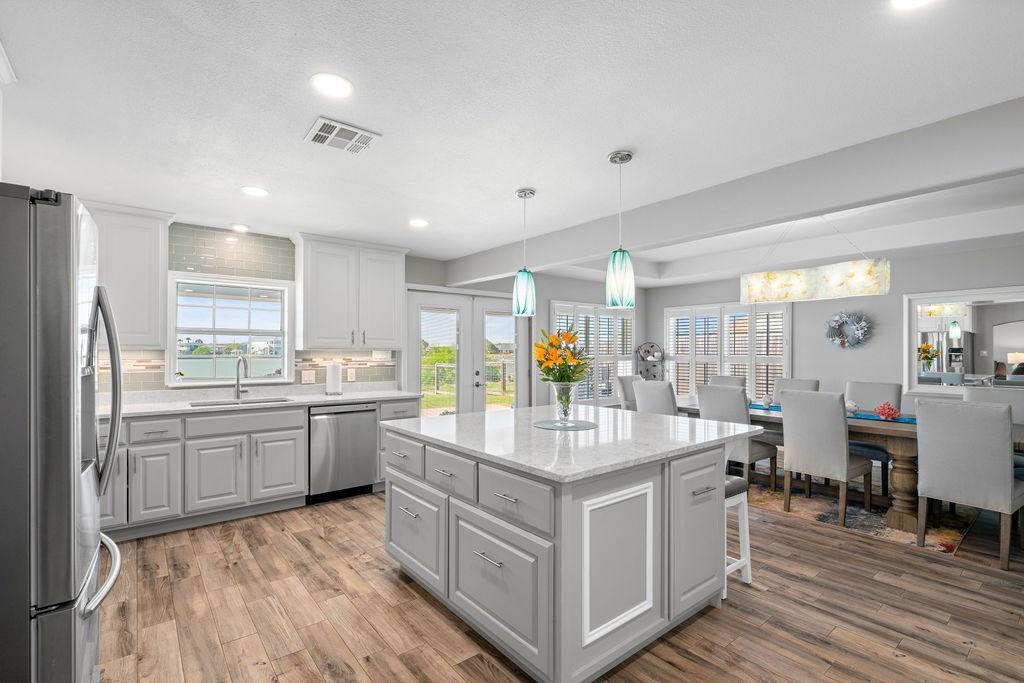 Coastal Luxury Meets Everyday Comfort. Discover the ultimate in waterfront living with this beautifully updated one-story home offering stunning sunset views and direct water access with 120' of bulkheaded water frontage on Salt Lake and proximity to enter Copano Bay. Whether you're entertaining or relaxing, this property is built to impress with both style and functionality. It begins with the Inviting Entry – charming front porch with custom pergola creates a fabulous cozy seating area to relax and begin or end your day. Huge Chef's Gourmet Kitchen and adjoining complimentary dining room space – Featuring huge center island, the focal point for fun gatherings, with electricity, rolling spice drawer, soft-close cabinetry, and extra-deep drawers for all your culinary needs, Quartz countertops, spacious pantry, stainless steel appliances and impressive Kabibe Shell Chandelier from the Philippines hangs above the dining room table. Open Living room with unique lighting feature in the trey-ceiling with French doors opening to breathtaking forever water views. Primary Suite Retreat – Unwind in a spa-inspired en-suite bath with a huge walk-in shower, double sink vanity, impressive wood treatment accent wall. Beautiful wood-like tile flooring throughout most of the house. Waterside 3rd Bedroom – Perfect for guests or a private home office. Expansive Outdoor Spaces – A massive covered back porch with 4 ceiling fans overlooks Salt Lake and your private beach area, perfect for entertaining or quiet evenings by the fire pit and enjoying abundance of birds and magnificent sunsets. Three-Car Garage/Workshop – Ample space for storage, hobbies, or your next big project. RV hook-up with 50-amp service. New HVAC system, hot water heater, roof 2017, asphalted driveway and more. This Rockport gem offers the perfect blend of modern amenities and tranquil coastal vibes. Come experience it for yourself—your dream home awaits!