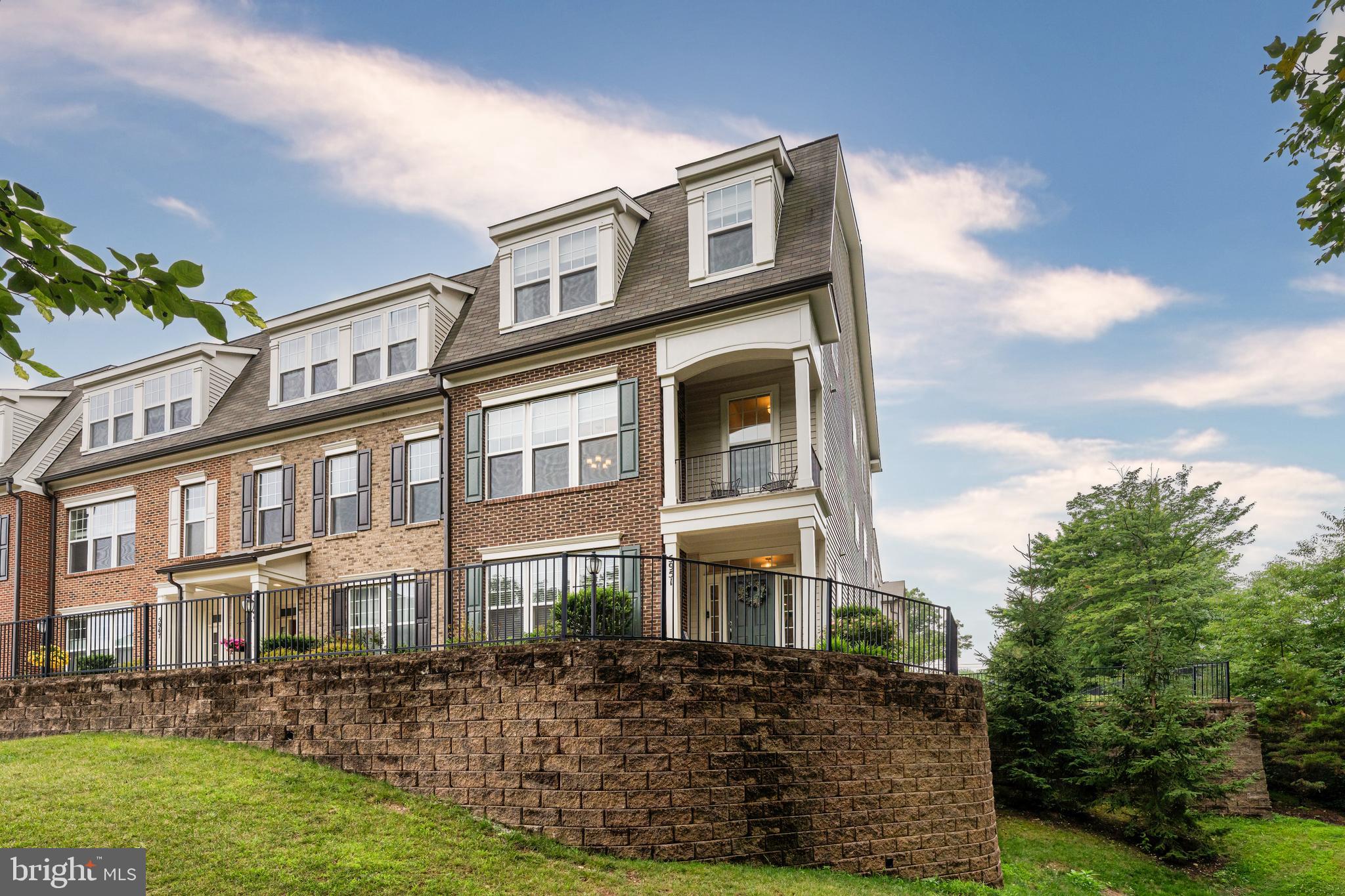 A rare opportunity to own a gorgeous end-unit residence in highly desirable Walhaven at Kingstowne, a boutique 55+ active adult community by Miller & Smith. This exceptional 3-bedroom, 3.5-bath home offers elevator access, a 2-car garage, and a thoughtfully designed layout that blends comfort, convenience, and low-maintenance living — ideal for those seeking a vibrant lifestyle within an active adult community. The entry level provides valuable flexibility with a private office that can also serve as a bedroom, a full bath, a spacious family room, and direct access to the 2-car garage. Elevator access from this level enhances the home's functionality, creating an easy connection between floors and supporting long-term convenience. Whether used for remote work, hobby space, guest suite, or additional daily living, this level offers a practical extension of the home's overall layout. The main level unfolds with open, light-filled living spaces designed for both everyday comfort and entertaining. The living room is anchored by an elegant gas fireplace and opens directly to a screened-in porch, creating a seamless indoor-outdoor connection. The dining room offers direct access to a balcony, adding another private outdoor space for morning coffee, evening relaxation, or casual entertaining. The kitchen is designed for both style and function, featuring white custom cabinetry, an extra-large island, stainless steel appliances, a double-door pantry, and elevator access. Its central placement allows the kitchen to connect naturally with the surrounding living and dining areas, making the main level feel cohesive, efficient, and ideal for hosting. The upper level continues the home's comfortable and elegant design with a private primary suite featuring a walk-in closet and a well-appointed bath with dual vanities, a soaking tub, and a frameless glass shower. Two additional bedrooms, a full bath, and an upper-level laundry closet complete this floor, creating a functional and well-balanced layout for daily living, guests, or work-from-home needs. Additional highlights include wood flooring throughout key living areas, a 2-car garage, elevator access across the home, and multiple outdoor living spaces including the screened-in porch and balcony.  As a Walhaven resident, enjoy access to Kingstowne's community-wide amenities, including pools, fitness centers, walking trails, sports courts, and community centers that host year-round events and programs. Conveniently located near Kingstown Town Center, Franconia-Springfield Metro, Springfield Town Center, Greendale Golf Course, Potomac Yard, Old Town, Reagan Washington National Airport, and major commuter routes, 5951 Clapton Court offers a refined combination of space, convenience, and connected 55+ living in Northern Virginia's Walhaven at Kingstowne community.