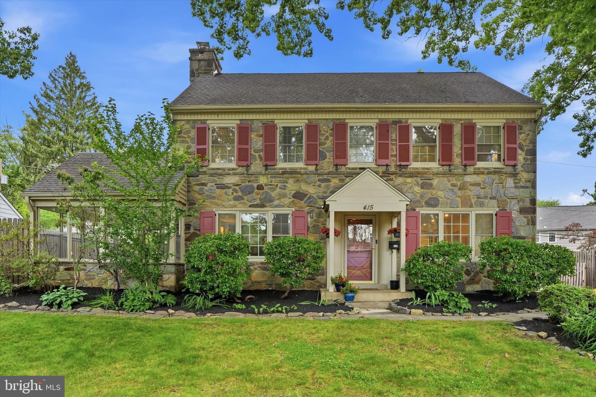 Welcome to 415 Charles Lane, a quintessential stone Colonial tucked away in the heart of Wynnewood’s coveted Shortridge neighborhood. This elegant residence perfectly captures the timeless craftsmanship of its era while offering the thoughtful layout and modern comforts today’s lifestyle demands. With five bedrooms and three and a half bathrooms spread across three finished levels, there is a sense of grace and scale found in every corner of this home.The main level invites you in with a bright, sun-drenched living room anchored by a classic stone wood-burning fireplace—the perfect spot for crisp autumn evenings. From here, step out onto the private enclosed patio, an ideal retreat for morning coffee or alfresco dining. The heart of the home has been reimagined for modern living, featuring a seamless, open-concept kitchen and dining area. This expansive space is perfect for both casual morning meals and sophisticated hosting, allowing for a natural flow that keeps everyone connected. A convenient powder room completes this level.Upstairs, the second level features a serene primary suite complete with two closets and a private en-suite bath that has been tastefully refreshed with brand-new flooring and a stylish new vanity. Three additional well-proportioned bedrooms on this floor share a full hall bath, providing plenty of space and flexibility. The third level offers a private fifth bedroom with its own full bath, making it a versatile sanctuary for guests or a quiet home office, complemented by a large floored attic for all your storage needs.The exterior is just as enchanting as the interior. A lush yard filled with specimen trees and a carefully curated year-round garden offers a peaceful outdoor escape. Practicality meets style with a two-car attached garage and a location that puts the best of the Main Line within easy reach. Located in the award-winning Lower Merion School District, this home is moments away from local parks, vibrant shopping districts, and seamless transit options for a quick commute to Center City. This is a rare opportunity to own a piece of Wynnewood’s storied charm.  Neighbors here organize multiple block parties each year, a Turkey Trot, and other community activities!