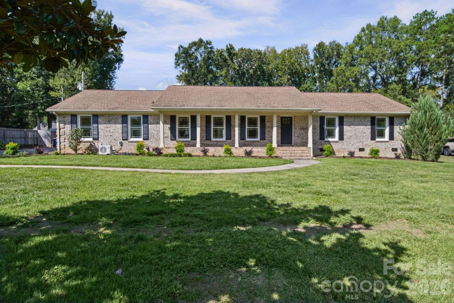 Exceptionally updated & truly move-in ready! Beautifully renovated 3-bed, 2.5-bath home on a spacious 0.85-acre lot in Mint Hill’s Farmwood neighborhood. No HOA. This 2,781 sq ft home (1974) features a stunning brand-new kitchen with quartz counters, new cabinets, all-new appliances & commercial fridge/freezer. Baths reimagined with 24×48 tile. New LVP flooring throughout, all-new vinyl windows, exterior doors, interior doors & hardware. Large tankless water heater, custom closet systems, new mini-split in spare room & conditioned crawl. Wood-burning fireplace, inviting deck & beautiful large outdoor fountain. Plus impressive 868 sq ft workshop and two additional storage buildings. Quiet neighborhood with mature trees, close to schools, shopping, dining & easy access to I-485, Matthews & Charlotte.
