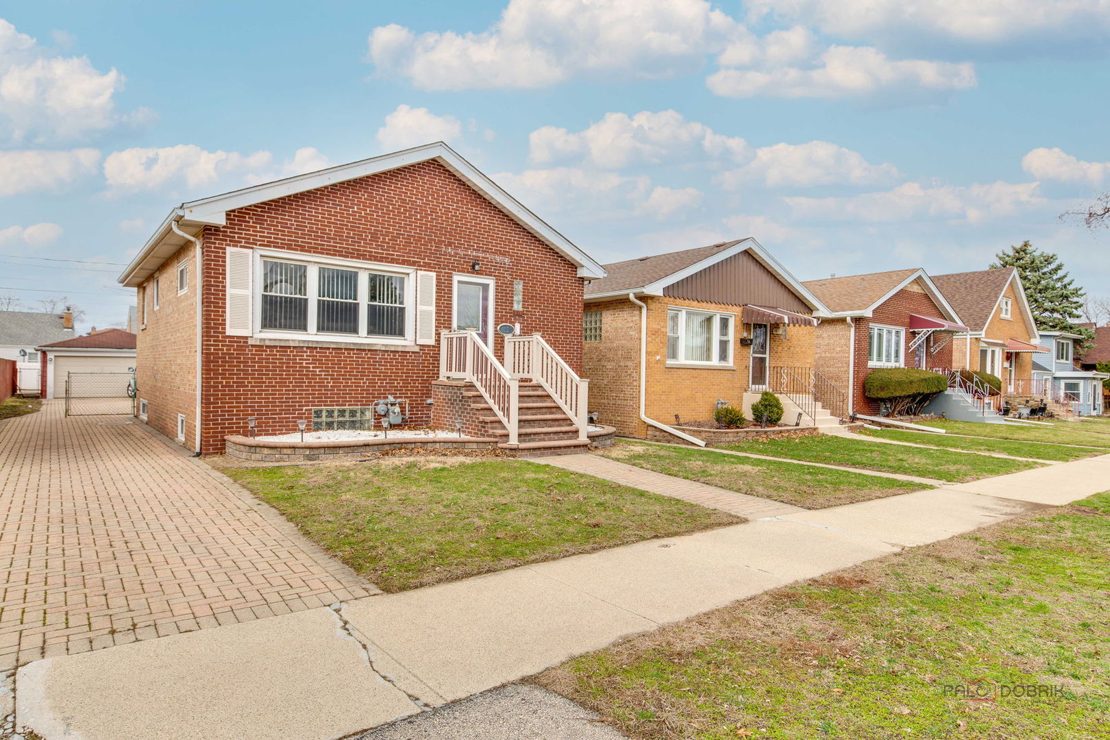 Solid brick home on a quiet residential block with low taxes! Spacious living room and bright eat-in kitchen with walk-in pantry. Main level offers two comfortable bedrooms and a full bath. Finished lower level adds a large family room, office (currently used as a 3rd bedroom), and a second full bath - ideal for guests, work-from-home, or extended living. Rear deck overlooks fully fenced backyard. 2-car detached garage plus generous paver brick driveway. Property is part of an estate and is being sold As-Is.