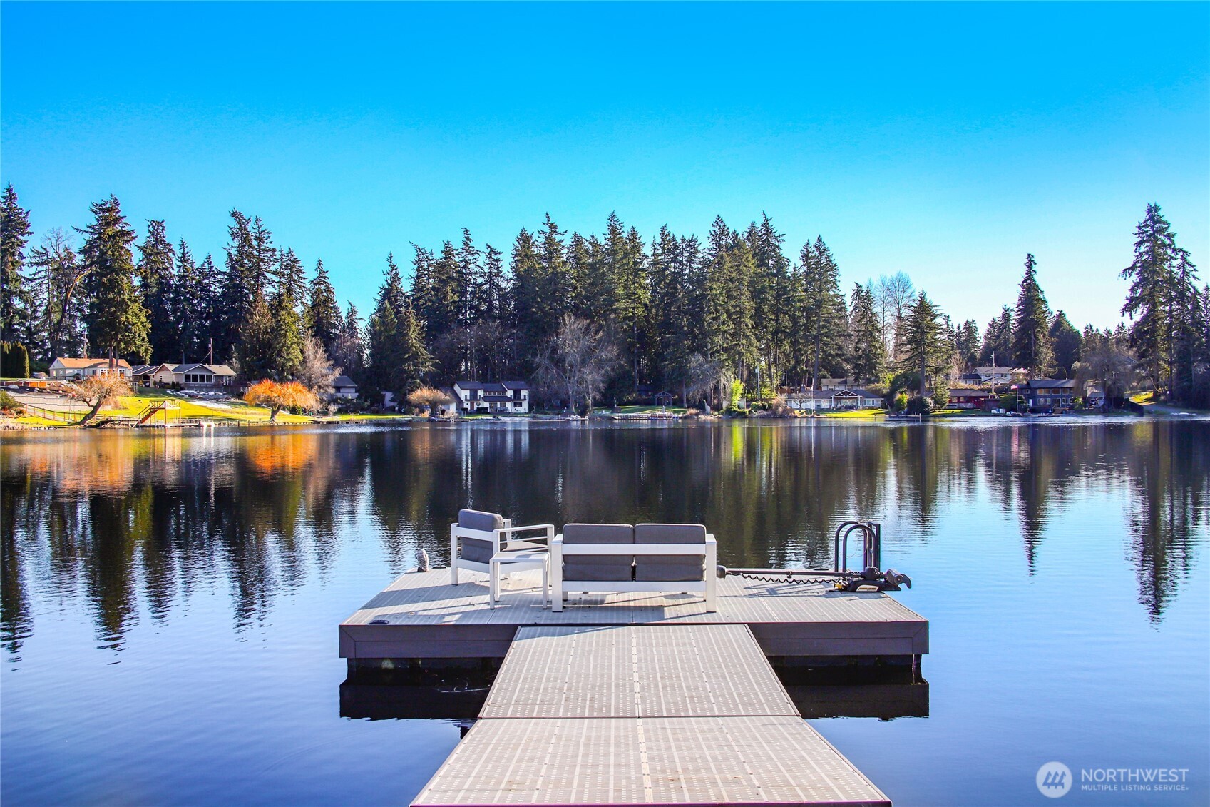 50+' Low Bank spring fed Trout Lake waterfront, w/own private floating dock that converts to a barge for serene loops around the lake. Live amongst nature & wildlife in peaceful setting. Enjoy variety of recreational activities: swimming, floating, kayaking, fishing, & boating right from your own backyard. Mature cultivated landscaping w/garden spaces. Lakeview entertaining at it's best! Quality features: Chefs dream kitchen, w/Viking Pro Series stainless appl w/double ovens & trash compactor, quarts counters, & LVT. 5" floor molding, recessed lighting, gorgeous hardwood floors, heat pump & so much more. Main floor has 3 bedrooms & bath. Upstairs has 3 more rooms, 1 w/AMAZING lake views. Driveway parking for 4 vehicles PLUS RV. NO HOA.  Septic design is for 3 bedrooms, but there are other rooms that could be used as a 4th or office or bonus.