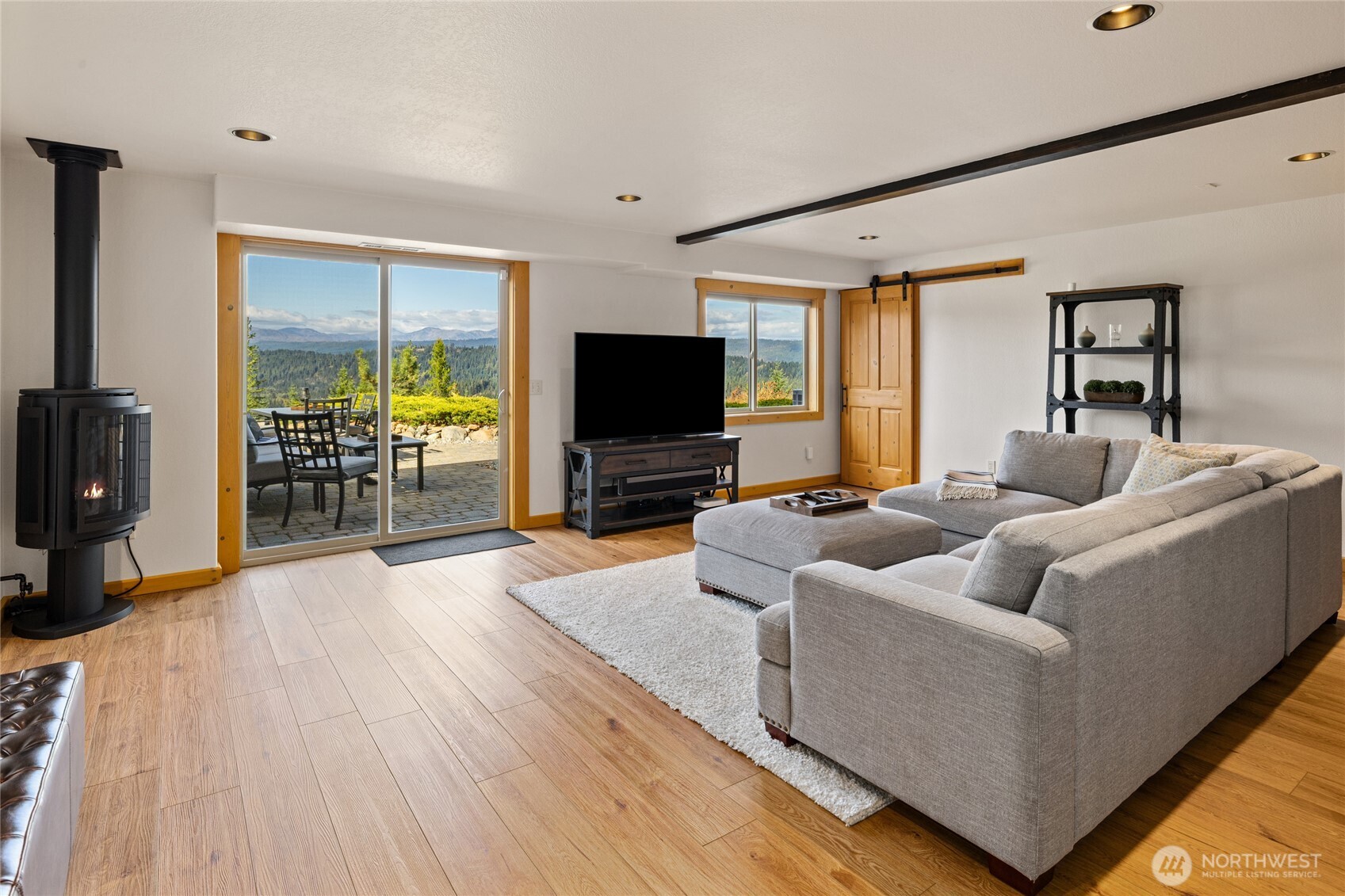 Spacious lower-level living area with a freestanding propane stove, patio access, and expansive views.