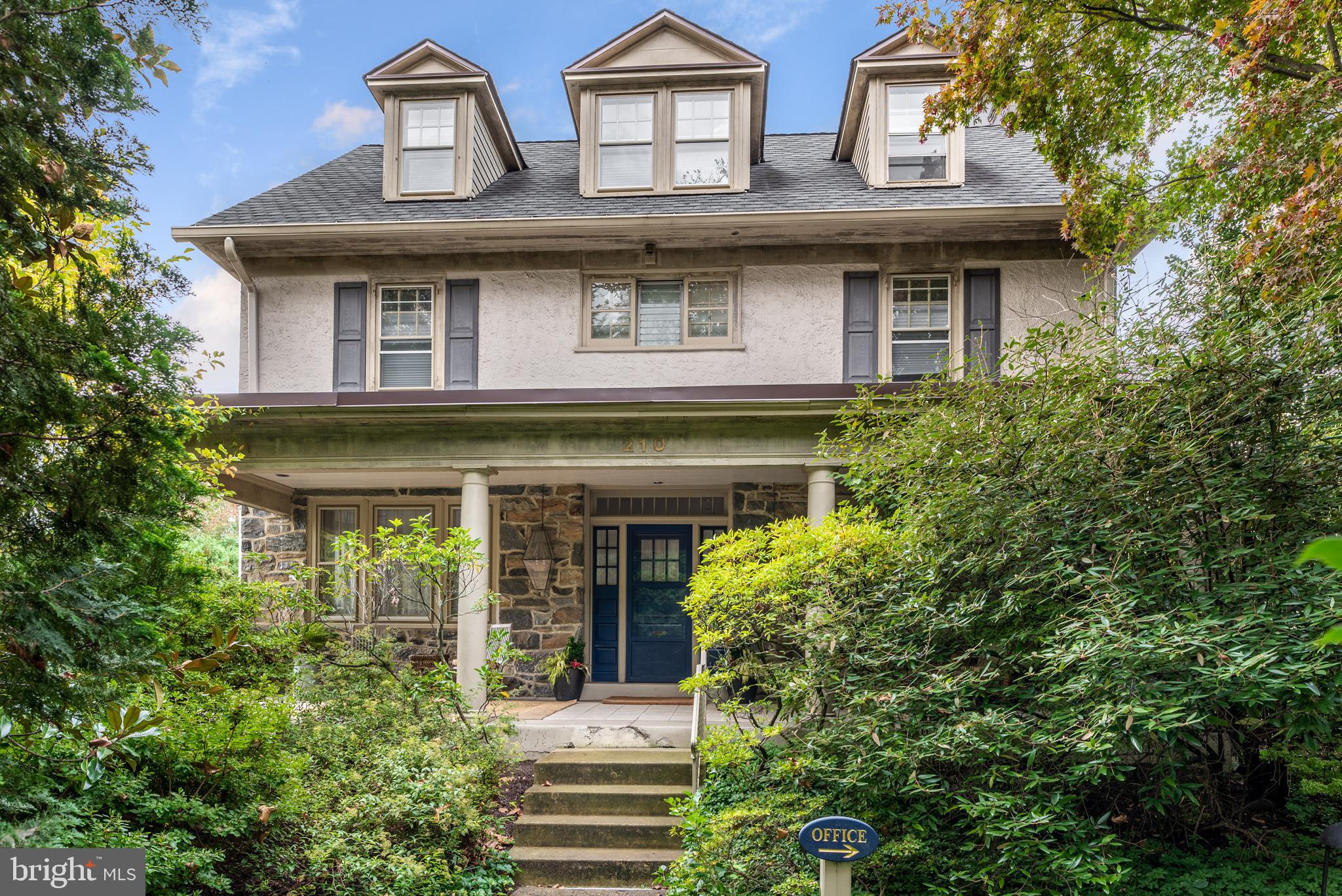 Welcome to 210 Kent Road, a premier 6-bedroom, 3+ bath stone classic in highly sought-after Ardmore. Thoughtfully updated while preserving its early c.1900’s soul, this home features detailed millwork, wood floors, solid doors, authentic hardware and deep-silled windows throughout. An idyllic open-air porch serves as an extra parlor for relaxation. The welcoming foyer leads to a fireside living room and a formal dining room designed for gatherings. The heart of the home is the sun-filled chef's eat-in kitchen, featuring ample cabinets space, quality appliances, a large island, spacious sun-filled breakfast area that seamless flow to the deck. A powder room, pantry and back staircase complement the main level.A standout feature is the private professional office with its own entrance and powder room—perfect for a home business or a main-floor in-law suite. Ascend via the main or the charming back staircase to the private quarters. The Primary Suite is a bright, sunny sanctuary with ample closets on the second floor featuring a spa-like luxury bath with a soaking tub, separate stall shower, and double vanity. The second level has three additional bedrooms, with unique attached storage spaces as well as a hall bathroom. The third floor features two additional bedrooms, one of which is quite large, offering ample space, natural light and architectural interest. A cedar closet is found in the third floor hallway.  These rooms provide endless possibilities for teens, guests, nursery, library, or hobby space. The hall bath is a combination bath and laundry space. This level is extremely bright. The property boasts a private driveway with two car detached garage. The level, private yard backs directly onto the peaceful, community Packer Park and Garden. Enjoy unmatched walkability to Suburban Square’s shops, Arnold Field, and the Ardmore train station for an easy commute to Philadelphia, NYC, and DC by regional rail and Amtrak service.