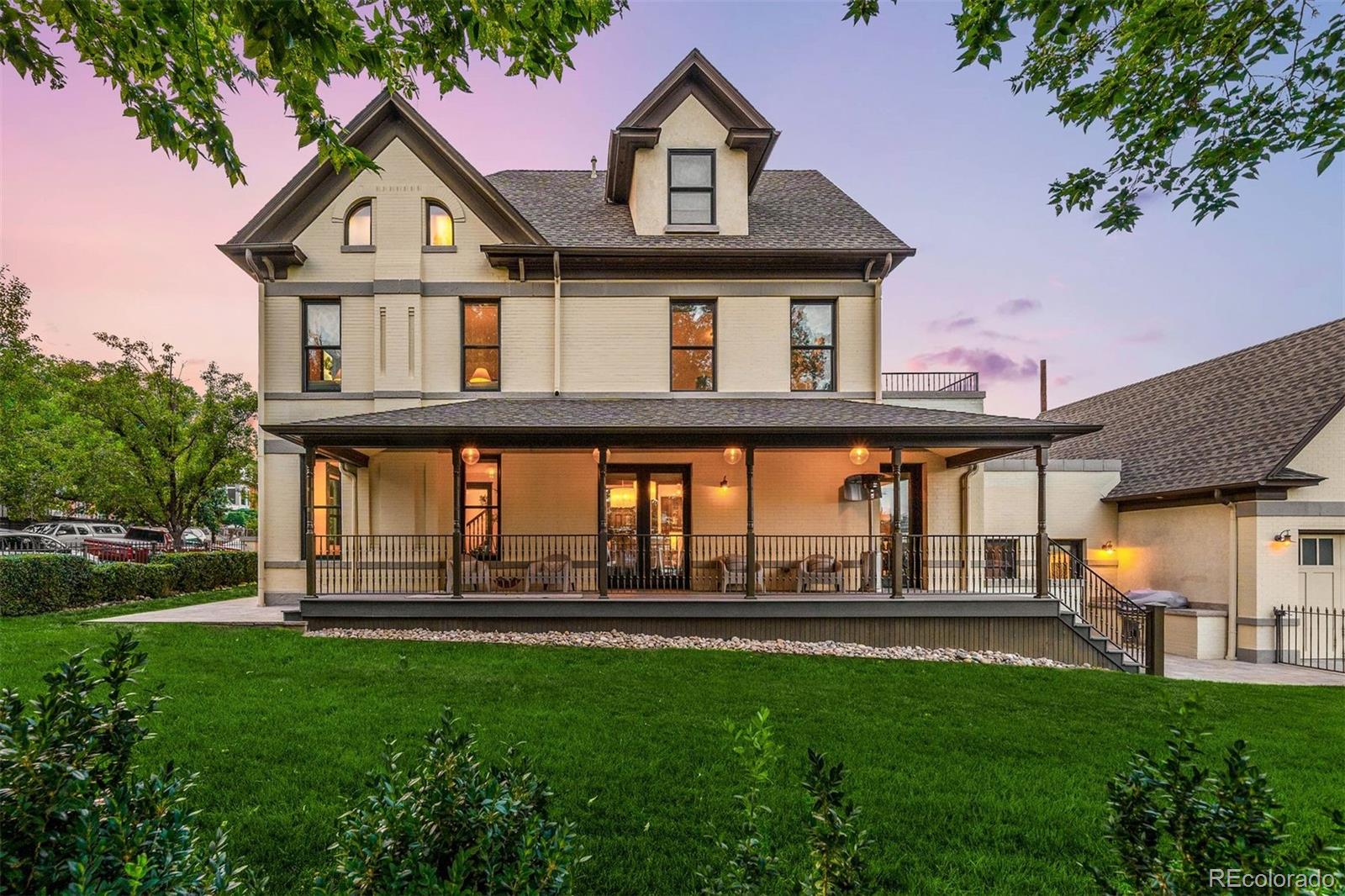 Not every home has a front row seat to one of the most desirable neighborhoods in Denver. A rarely seen covered wraparound porch sets the tone, inviting neighbors to stop and chat, friends to linger after dinner, and mornings to begin a little slower. Set on one of LoHi's most charming corners, this meticulously restored Victorian is rich with craftsmanship that makes historic homes so beloved, from intricate wood moldings to soaring ceilings and timeless details preserved with care. Inside, the living room is anchored by a dramatic fireplace framed by oversized windows, flowing into the formal dining room. French doors open to the porch, making outdoor dinners feel like a natural extension of the home. Beyond, the gourmet kitchen is appointed with an oversized eat-in island, coffee station, professional-grade Thermador appliances-48-inch six-burner gas range + double ovens-and exceptional storage. Descend to a dedicated bar level, complete with a sink and beverage refrigerator, a rare bonus area ideal as a backdrop for happy hour with friends. A proper laundry room with a utility sink is tucked off the kitchen. Two secondary bedrooms with en-suite baths are thoughtfully positioned on the second level, including one with custom built-ins, ideal as a study, opening to a spacious balcony with Denver skyline views. On the third floor, the primary suite enjoys a remarkable sense of privacy. A spa-inspired bath with a soaking tub, walk-in shower, dual vanities, and nearly 7x10 custom walk-in closet complete the space. The oversized attached two-car garage with epoxy floors and built-in cabinetry reflects the same attention to detail. Outside, the corner lot offers a rare advantage in LoHi - a fully fenced wraparound yard with abundant green space and an outdoor kitchen. Just beyond the front gate, Happy Camper, Avanti, Little Man's, and all the acclaimed LoHi gems are around the block! Special Financing Incentives available from SIRVA Mortgage.