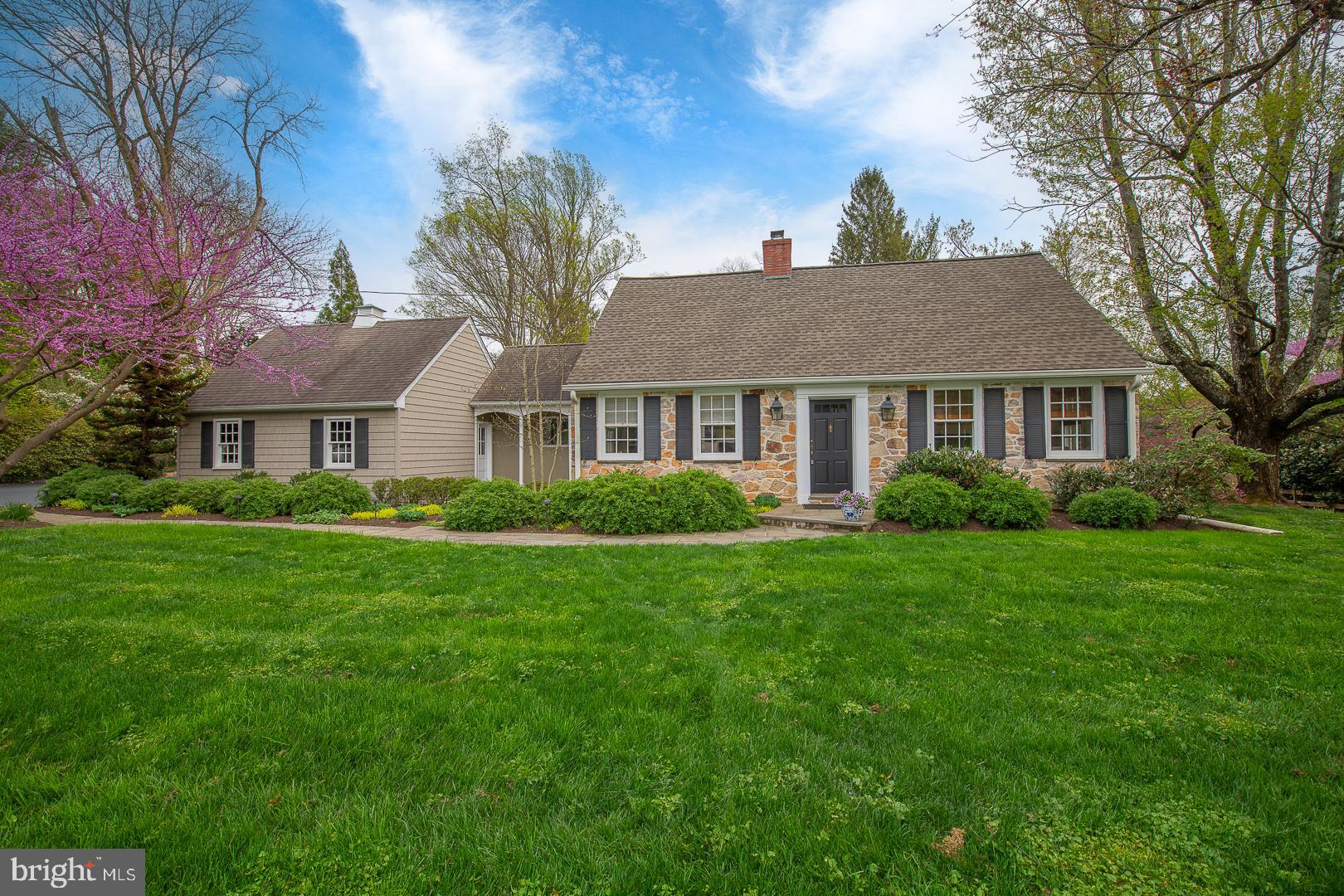This is the house everyone has been waiting for-- both "downsizers" looking for first-floor living, and those seeking wonderful amenities like top-rated schools and an engaging community.  Here it is: a Classic Cape Cod stone 3-4 bedroom home with a highly-desirable first-floor primary bedroom suite (bedroom, bath, walk-in closets and library/office). Low taxes and minimal maintenance set the stage for a comfortable existence, and a relaxing, custom-designed cedar porch with "invisible" screens" provides three-season enjoyment of the serene 1.1 acre lot. Nestled up against the house is the spacious and beautiful Pennsylvania bluestone patio area for al fresco entertaining or nature gazing. You are just minutes from a great meal at one of the excellent Wayne restaurants or hop the nearby train to a downtown evening. Even the airport is closer from this fabulous location than most area homes. Live entirely on the first floor with extra rooms to create whatever your lifestyle dictates (the den could easily be a sitting room, second office, fourth bedroom, gym or nursery) and still have ample rooms upstairs for children/guests. Almost 40 years of pride of ownership is displayed in this home. Three zone heating, top-of-the-line Trane high efficiency heat pump, high-end built-in dehumidifying system, custom master cabinetry, California closets, exterior siding and trim requiring no painting, and gorgeous landscaping with perennials galore all await you. Enjoy your morning coffee in the sunny breakfast room and cook your favorite meals in the well-laid-out kitchen with an adjacent formal dining room, for those large communal gatherings. The living/family room invites reading by the fire or watching your favorite TV shows. A full hall bath serves the two rooms off the primary bedroom, one of which is set up as an office and the other as a den, a room easily converted to a fourth bedroom with the addition of a set of closet doors in the nook area. So many options. The primary bedroom is a light-filled spacious retreat in the rear of the home, with views of the private back yard and direct access to the lovely blue-stone patio. The ensuite primary bath has double sinks, custom cabinetry and a tiled shower with a seating area. Two large rooms, a full bath and additional storage areas round out the living spaces in the home upstairs. The basement is shelved for all your storage needs, and houses the utilities, including an 88-gallon water heater and a double-walled, corrosion-resistant oil tank. (Homes nearby have converted to gas if that suits you.) The attached 2-car garage with pull-down stairs to a floored attic provides tons of extra space for all of your sports equipment and gardening implements. The location really cannot be beat. Medical facilities, luxury retail shops, abundant public gardens, trails, parks and two commuter rail stations are all only minutes away. This home has it all and will not last. Come see for yourself what your next stop in life could be.