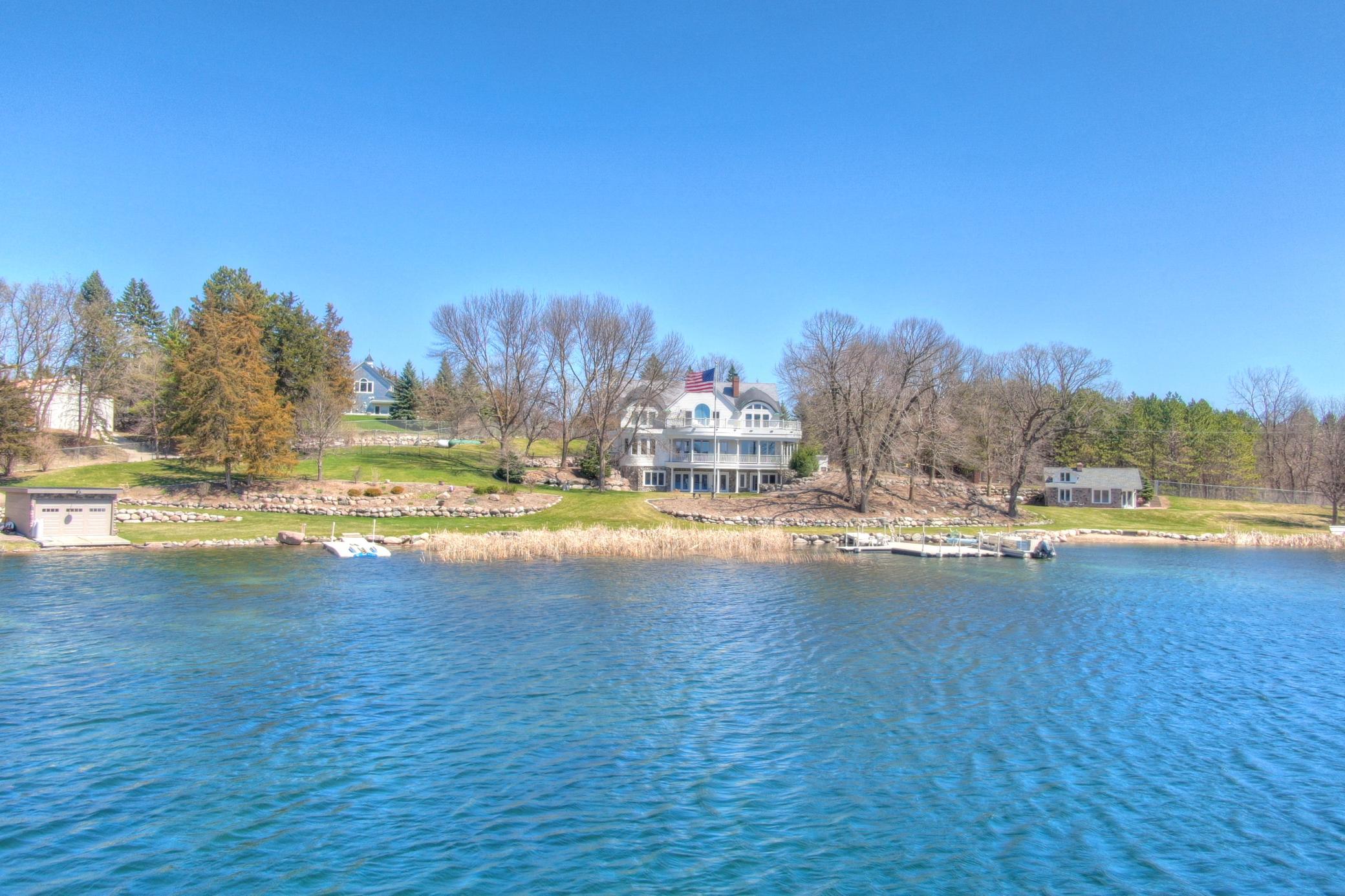 Welcome to this stunning custom-built executive home on the crystal-clear water of West Lake Sylvia, one of Minnesota's most prestigious recreational lakes. This timeless lakeshore features a 1.8-acre lot with park like landscaping, 385 feet of gentle sloping shoreline, and rare amenities including a guest cottage and boathouse, all just one hour from the Twin Cities. Every detail is thoughtfully designed to impress, from the copper roof accents and the gated , heated paver driveway to the fine millwork and custom cabinetry found throughout. The main level features rich woodwork, coffered ceilings, and hardwood floors. The chef's kitchen is equipped with Wolf and Sub-Zero appliances, double islands, granite countertops, and extensive built-ins perfect for entertaining. Enjoy open concept living with a spacious great room, cozy den with fireplace, covered deck, and informal dining, all oriented toward breathtaking views of Lake Sylvia. The primary suite offers vaulted ceilings, a private balcony, double sided fireplace, walk through closet and spa-inspired bath with soaking tub, dual vanities, and walk-in shower. Upstairs you'll find generously sized guest bedrooms, a wet-bar, and versatile flex space. The walkout lower level includes a large family room, theater room, second kitchen, stone fireplace, sauna and direct access to the lakeside patio and gardens. Outside, enjoy lush landscaping, paver walkways, and multiple outdoor living areas ideal for relaxing and entertaining by the water. This is a rare opportunity to own this phenomenal property. Schedule your private showing today, homes like this are seldom offered.