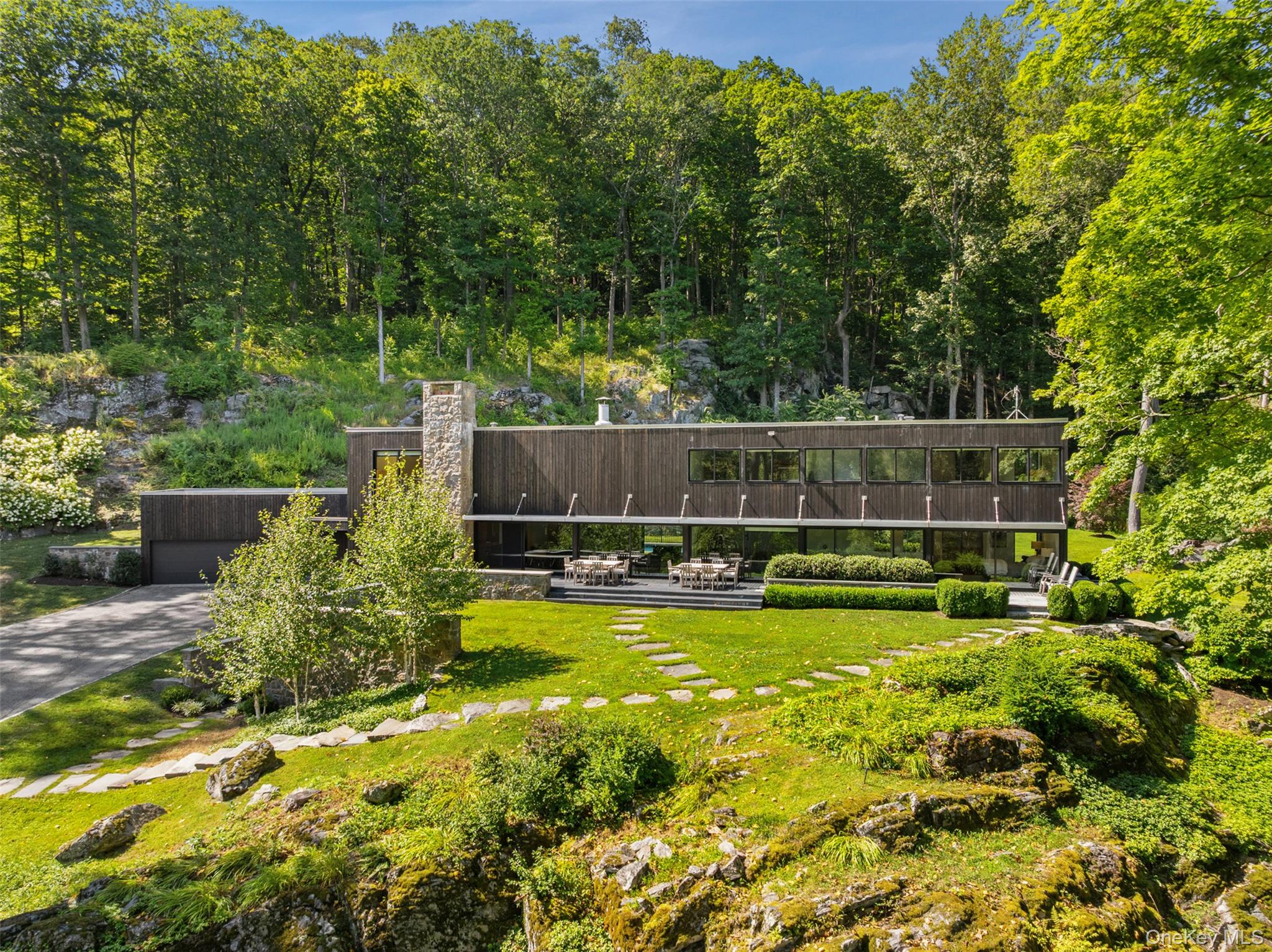 Experience modern design in perfect harmony with nature at 147 Mianus River Road. Originally created by master builder John Tishman (The World Trade Center, Sears Tower, John Hancock Building), the home was artfully reimagined in 2019 by AIA award–winning architect Belmont Freeman, who introduced luxurious modern finishes while preserving the simple lines and gracious spaces of the original design.  A dramatic two-story great room, with walls of glass and soaring 17-foot ceilings, creates a seamless connection between indoor and outdoor living. With 5 bedrooms and 5 baths, the home offers generous accommodations for family and guests. Outdoors, a sweeping drive, gated entry and a negative-ionization, low-chlorine pool, complete this private estate setting. Set on more than 5 private, tranquil acres and just steps from the Mianus River Gorge Preserve and minutes to Bedford Village. Majestic views surround this iconic contemporary in every season. 1 hour from NYC.