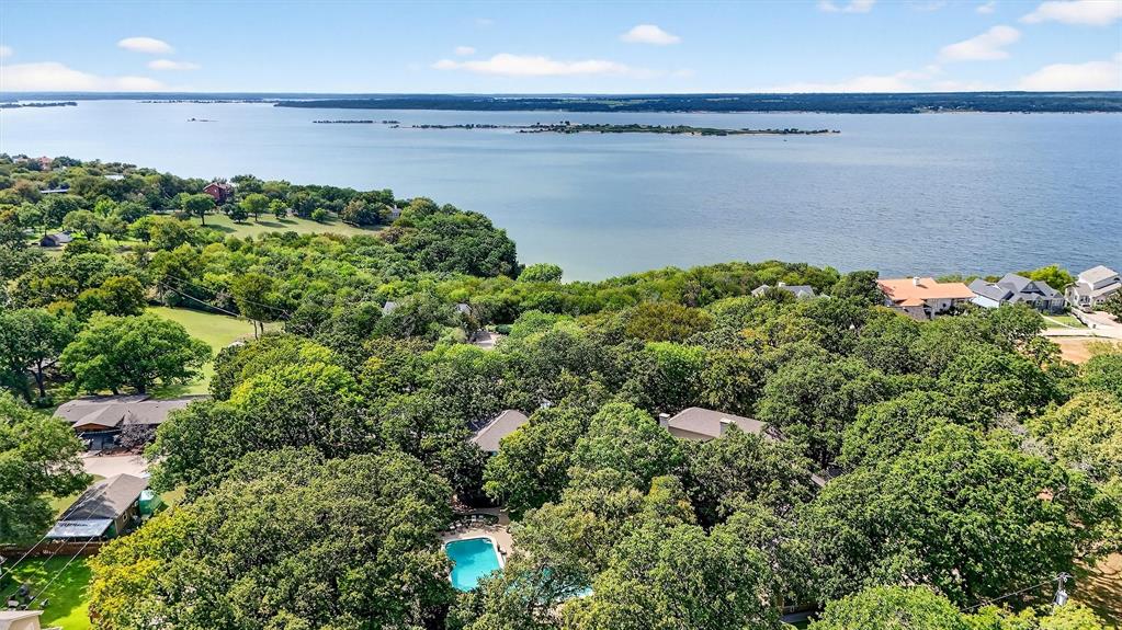 Experience exceptional design, comfort, and lakeside luxury in this custom 5 bedroom, 5.5 bath estate located in the heart of Pottsboro. Spanning over 7,500 sq ft and nestled on a beautifully landscaped 1.17 acre lot, this home was built for upscale entertaining and private retreat living. From the moment you step inside, you're greeted with vaulted ceilings in both the living and dining rooms and a fireplace that anchors the main living space. A second fireplace in the expansive primary suite adds warmth and comfort to your personal retreat. The huge primary suite is designed to impress featuring a jetted soaking tub, separate walk-in shower, and large his-and-hers walk-in closets. Inside the primary closet, you'll also find a dedicated secondary laundry space. A full main laundry room serves the rest of the home. Spacious kitchen featuring a breakfast bar, a large center island, granite countertops, and abundant cabinet and countertop space. The kitchen also includes stainless steel appliances and a window over the sink overlooking the backyard, providing natural light and serene views. Three secondary bedrooms each feature private ensuite bathrooms, offering comfort and privacy for family and guests. Designed for productivity and flexibility, the home offers a dedicated study with built-in cabinets plus an additional room offering versatility to be a bedroom, craft room, or second office. Step outside to your personal oasis with a large in ground pool, lush landscaping, mature trees, and multiple covered porches and balconies perfect for relaxing or entertaining. The property also includes a built in mosquito misting system to keep evenings comfortable. A spacious detached three-car garage includes full guest living quarters upstairs, featuring a living room with Murphy beds, a bedroom, kitchenette, and full bath. All of this comes together to offer a perfect blend of privacy, space, and upscale amenities making this an extraordinary place to call home.