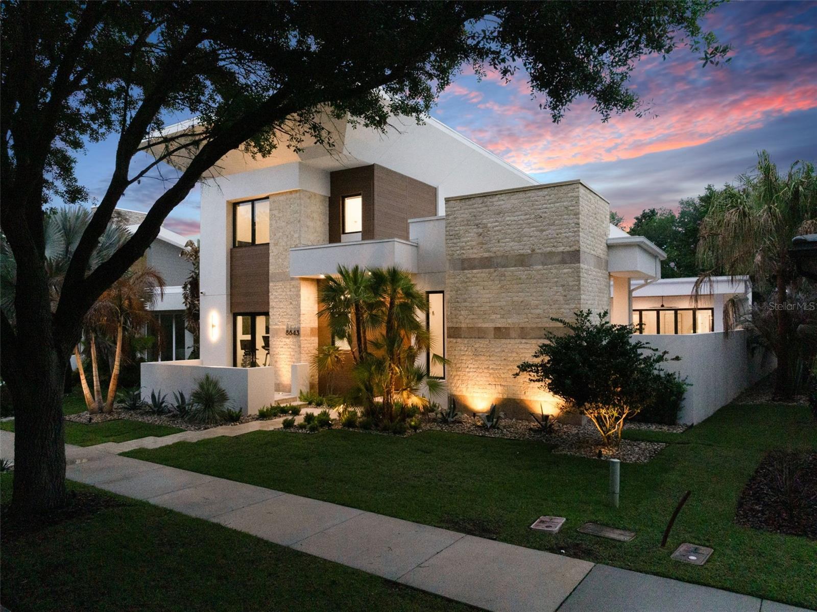 Welcome to 8643 Farthington Way, a newly built (2025) courtyard pool estate offering 5 bedrooms, 5 full bathrooms, and 2 half baths, where elevated design and resort-style living come together in one exceptional residence.Centered around a stunning private courtyard, the home is designed to maximize both privacy and indoor-outdoor living. The courtyard showcases a gorgeous pool and spa, complemented by lush turf and a fully equipped summer kitchen, creating a true private oasis ideal for both intimate relaxation and elevated entertaining. Expansive glass doors and thoughtfully positioned living spaces capture views of this showpiece from throughout the home.Inside, grand ceilings, clean architectural lines, and an abundance of natural light define the main living areas. The open-concept layout offers a seamless flow between the kitchen, dining, and living spaces, all enhanced by newly installed electronic shades for both convenience and ambiance.The main level is designed for effortless living, featuring all primary spaces including the main living areas, a luxurious primary suite, a secondary bedroom, and laundry. The primary suite offers a private retreat with generous proportions, spa-inspired finishes, and beautifully designed closet space.Upstairs, the home offers exceptional flexibility with two distinct wings. The front staircase leads to a private suite complete with bedroom, full bath, and dry bar, perfect for guests or extended stays. The rear staircase leads to an additional living level featuring two bedrooms, two full bathrooms, one half bath, a spacious loft, and a second laundry area, ideal for multi-generational living or added convenience.Completing the home is an oversized rear-loading 3-car garage with dedicated golf cart space, offering both functionality and a clean, elevated streetscape.This newly constructed residence presents a rare opportunity to own a thoughtfully designed, luxury courtyard home that perfectly balances privacy, scale, and lifestyle, located within the gates of Lake Nona Golf and Country Club, recognized as a Platinum Club of the World, this home offers access to one of Central Florida's most sought-after communities.