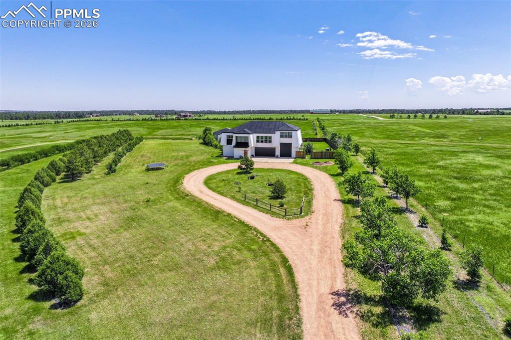 At the very end of a quiet private road, you’ll find a Colorado retreat that actually feels like one. Thirty-five acres of rolling, tree-studded landscape, wide-open skies, and complete privacy wrap around this modern farmhouse,creating the kind of lifestyle people imagine when they think of living in the country.Step inside and you're greeted with over 3,500 sq ft of thoughtfully crafted space. Real hardwood floors,custom railings, triple-pane windows, and 9-ft ceilings set the tone. The kitchen is the heart of the home with a massive island that seats eight, a gas range, and storage for days. It flows straight into a dining room framed by picture-perfect views, and the living room is anchored by a gorgeous stone fireplace with built-ins.The primary suite feels like its own getaway, tucked up a private staircase with oversized windows, a spa-inspired bath, and a generous walk-in closet. The lower level offers a theater room,another bedroom and full bath, plus a flexible living space ideal for guests, multigenerational living, or a private workspace. Car lovers, hobbyists, and entertainers will love the heated 1,500 sq ft attached garage it can fit up to six vehicles tandem or four plus a full-size RV, complete with hookups, clean-outs, water access, and room to gather. The 2,300 sq ft shop adds even more: fully insulated,heated, concrete floors, water, and 400-amp service.The property itself is a dream.Six fenced and cross-fenced pastures, healthy hay grass, over 2,000 mature trees and lilacs, plus rolling terrain that makes every sunset feel cinematic.A custom chicken coop and a privacy-fenced backyard round out the perfect country setup.You’re minutes from Homestead Ranch Regional Park and within a quick drive to schools and Falcon. Modern conveniences are already in place: 2-gig fiber internet, two water heaters,A/C, a water softener/filtration system, and a newer furnace. No matter where you stand inside or out the views are nothing short of incredible.