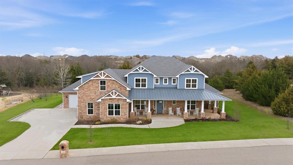 Discover a truly exceptional Craftsman-inspired estate nestled on nearly an acre of wooded, in-town serenity in one of Norman’s most desirable additions. Designed with both sophistication and practicality in mind, this custom residence blends timeless character with modern luxury and an impressive array of thoughtful upgrades. A welcoming wrap around front porch sets the tone as you enter a spacious interior anchored by a stunning gourmet kitchen, an entertainer’s dream, featuring oversized island, dual ovens, dual dishwashers, dual refrigerator hookups, 8-burner gas range, walk-in pantry, coffee bar with prep sink, and a picturesque farmhouse sink overlooking the lush backyard. The expansive living room offers a true wood-burning fireplace with gas starter, while the adjoining dining area accommodates large gatherings and long farmhouse-style tables with ease. A dedicated study, upstairs bonus room, and well-planned utility wing with two washer/dryer hookups and extra-large mudroom elevate everyday convenience. The primary suite is a private retreat with dual walk-in closets. One of which doubles as a spacious, climate-controlled walk-in storm shelter for peace of mind. Secondary bedrooms are equally distinctive, including a charming vaulted room with a ladder-accessed loft and Jack-and-Jill layout featuring dual half baths connected by a shared tub/shower. Outdoors, the property unfolds into a rare in-town oasis: mature trees, a meandering creek, peach and nectarine trees, and peaceful walking paths create an atmosphere that feels worlds away. The covered patio is perfectly positioned for relaxation or entertaining. With a new high-impact roof (2023), custom built-ins throughout, and designer finishes, this one-of-a-kind home delivers unmatched functionality, beauty, and craftsmanship. A true must-see for buyers seeking space, character, and luxury all within the heart of Norman.