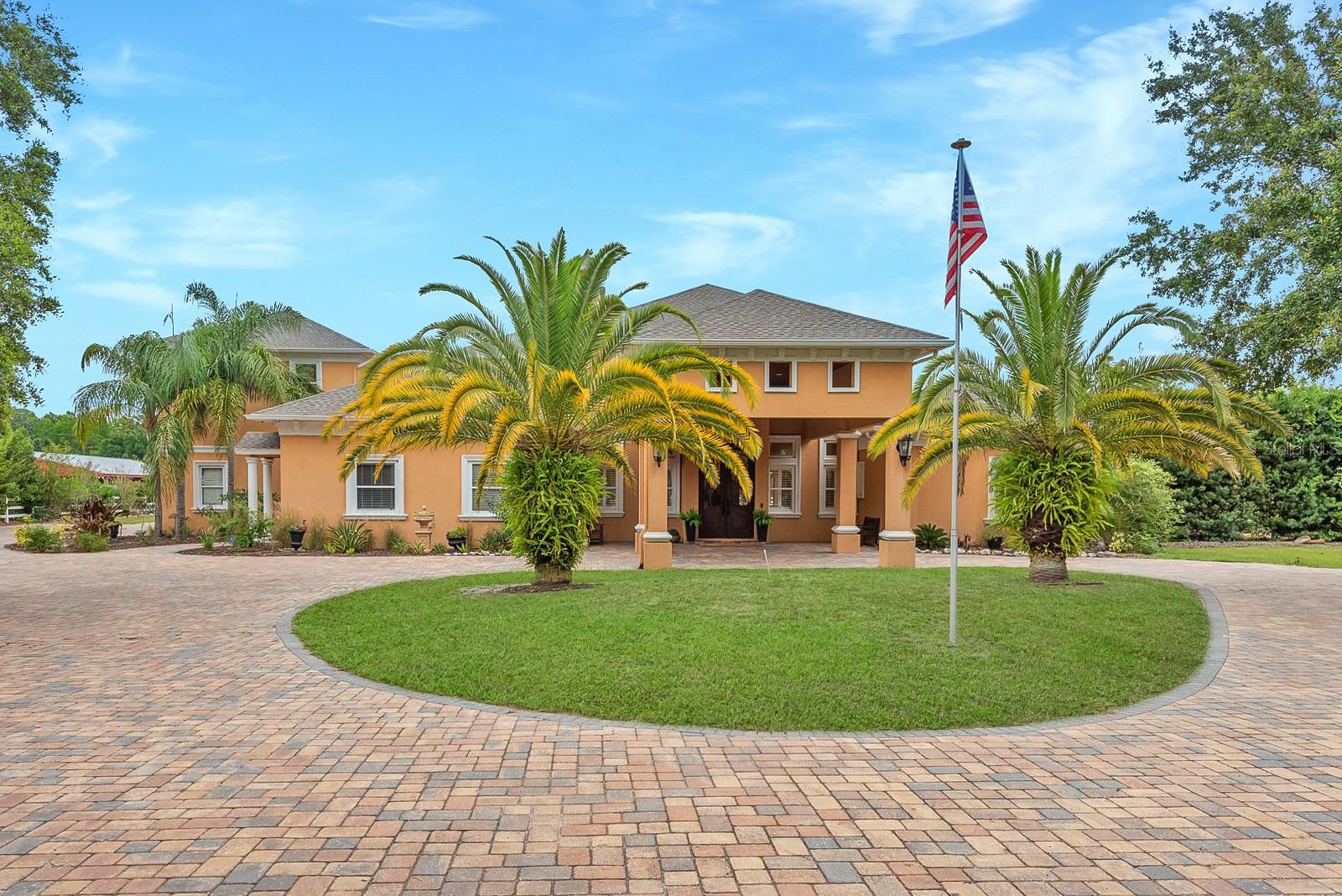 Equestrian Paradise with Luxurious Main Residence and Guest House

Welcome to your dream estate nestled within a prestigious gated equestrian community. Sprawling across 5.02 magnificent acres with 700 feet of tranquil pond frontage, this property truly delivers on the promise that you can have it all.

The main residence showcases 7,725 square feet of refined living space, beginning with an impressive porte-cochere entry. Inside, discover 6 bedrooms and 7 bathrooms thoughtfully designed for comfort and privacy. The elegant formal living and dining rooms provide perfect settings for sophisticated entertaining, first floor family room with its cozy fireplace offers a warm gathering space and a second floor family room with fireplace and built-ins.  Featuring marble travertine floors, coffered ceilings and crown molding.

Culinary enthusiasts will appreciate the gourmet kitchen featuring wood cabinetry, elegant granite countertops, an oversized center island with seating, serving station, wet bar and premium appliances including a gas cooktop and wine refrigerator.  A wonderful place where family can gather!

Entertainment options abound on the second floor with a game room, small kitchen and fully-equipped theatre room. Along with an  additional bedroom and full bathroom.

The sumptuous primary bedroom suite includes a fireplace, sitting area, walk-in closets, and a luxurious bathroom with dual vanities, separate shower, and garden tub. A private mother-in-law suite with its own kitchen, living room, bedroom, and bathroom offers ideal accommodations for extended family with a private entrance.

Outdoor living is equally impressive with a screened lanai, resort-style pool with waterfall, and standalone outdoor kitchen. A wonderful entertaining area! Gather around the stone fire pit on cool evenings or stroll the green pastures—perfect for horses!

The detached guest house provides additional living space with its own living room, kitchen, bedroom, bathroom, and flex space.

This rare property offers room for everyone and everything you've ever wanted.