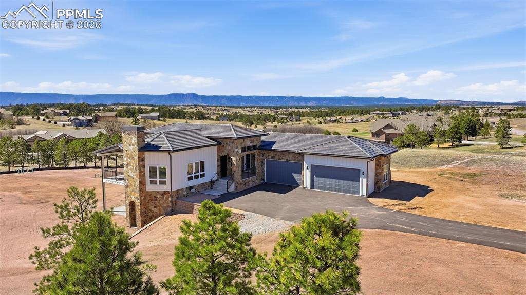 A Mark Beery custom designed home on one of the remaining homesites in picturesque Settlers Ranch. Views of magnificent Pikes Peak morning, noon and night. Mark's standard features are often considered extras in other custom-built homes - travertine tile surfaces, solid oak doors, milled cabinetry, and retractable window walls, just to name a few. This two-level home features a Master Bedroom Suite on the main level and three (3) additional bedrooms on the lower level with ten (10') ceilings for extra daylight. The Family Room features a wet bar and design options galore! Two of the three bedrooms have walk-out patios. The four (4) car garage expands to 6 in tandem parking is needed. GREAT, GREAT, Storage possibilities. Just a gorgeous lot lined with mature pine trees. Daily Tranquility Awaits!
