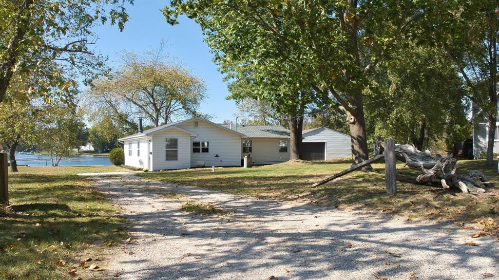 Your dream lakefront retreat is here! This low maintenance, move-in ready 3 bedroom, 2 bath ranch offers over 168 feet of private frontage on Doc and Tom Lake, a 300 acre, all-sports lake perfect for year-round recreation including boating, fishing, swimming, kayaking, and snowmobiling. Situated on a quiet 1/3-acre cul-de-sac lot within the highly desirable Lake of the Pines Association, this home combines peaceful lake living with resort style amenities including a clubhouse, heated pool, private campground, member rental cabins, pontoon island, outdoor pavilion, walking trails, hunting land, and a full calendar of family friendly and adult events throughout the year. Originally built with charm and thoughtfully expanded in 1998 to nearly double its original size, the home features open concept living with a bright entryway leading to an inviting kitchen with a center island, pantry cabinet, ceramic tile flooring and dining area, which flows seamlessly into a large great room with a wood-burning stove, and a door wall framing spectacular lake views. The private primary suite offers an en-suite bath, skylight, and sliding door wall to the back deck which overlooks the water. Two additional bedrooms, a laundry/utility closet, and central air conditioning complete the functional interior. Enjoy morning coffee or evening sunsets from your lakeside deck, with plenty of space for outdoor dining, entertaining, or relaxing by the firepit. Additional features include central air, vinyl replacement windows, natural gas, a Blink video doorbell and a 720 square foot heated garage/outbuilding, perfect for storing cars, boats, ATVs, snowmobiles, or setting up a workshop. Recent updates include a new dimensional shingle roof (2024), new septic field (2021), well pump, blown-in attic insulation, carpeting, interior paint and blinds. All appliances are included, and the property is agent owned. Whether you're seeking a peaceful getaway, a permanent residence, or a place to make lifelong lake memories, this turnkey home is a rare