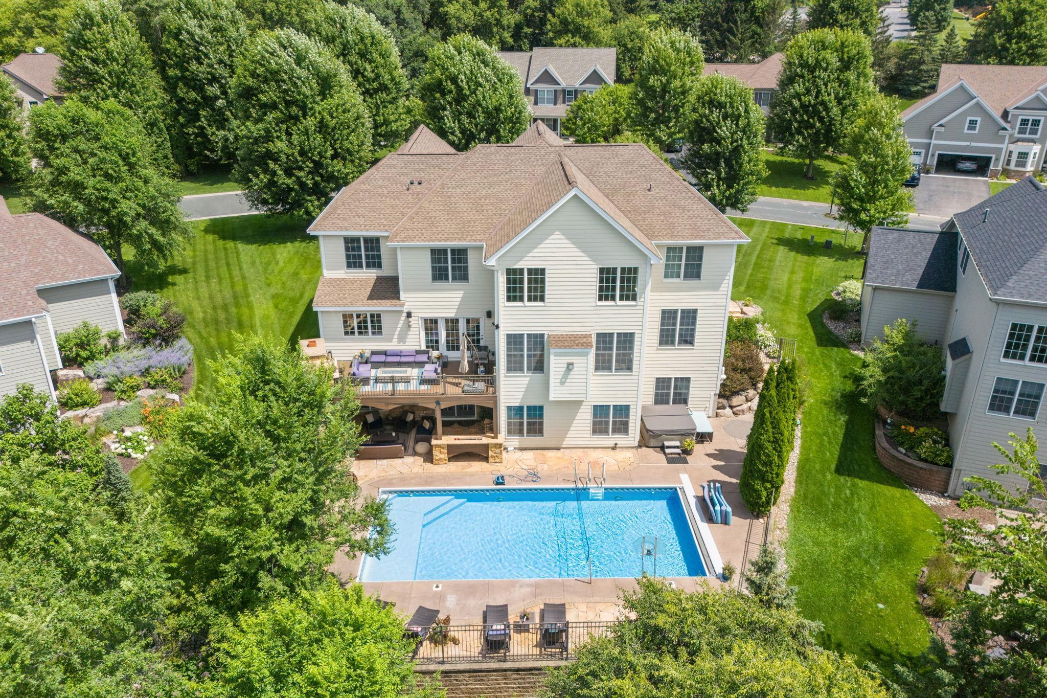 Some homes impress at first glance and some  deepen over time. This 6 bedroom 6 bath walkout two story does both.  From the grand foyer with iron baluster staircase, every square foot of this Steeplechase residence is composed for visual flow and entertainment. The main level moves from formal living and dining spaces — detailed with crown molding, soffits, and accent lighting — to a great room anchored by a floor-to-ceiling stone fireplace and walls of windows. The renovated kitchen shines with quartz countertops, enameled cabinetry with glass fronts, dual ovens, and oversized island, all facing the pool and pond beyond. Upstairs, the primary suite unfolds across nearly 700 square feet, featuring four custom closets, a private sitting area, and a luxury bath with heated stone floors, soaking tub, and full-body spa shower. Every secondary bedroom has either a private or semi-private bath — all with granite finishes and tile surrounds.  AMAZING!  
The lower level expands possibilities: a walk-out family room, tiered theater, full bar with wine refrigerators suitable for any size party, and a sixth bedroom suite. And the kicker is the outside, with multiple patios, fireplaces, and a heated in-ground pool creating a four-season resort feel — backed by preserve views and nightly sunsets.  Crafted not just for function, but for rhythm. Built to live beautifully.