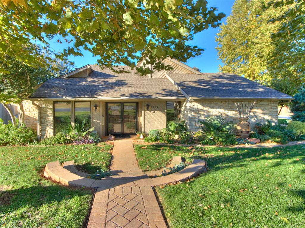 Discover a one-of-a-kind contemporary retreat centered around a stunning open-air atrium that brings natural light and serenity into every corner of the home.  Thoughtfully designed so that nearly every room overlooks this captivating centerpiece, the layout feels both modern and peaceful, creating a true indoor-outdoor living experience.  The front door opens into a spacious living room with warm natural light and a charming side nook-perfect for reading, relaxing or customizing into your ideal flex space.  Just off of the living room sits the dining room, which flows seamlessly into the kitchen for easy entertaining.  The kitchen, breakfast area, and family room are anchored by a beautiful stacked-stone, double-sided fireplace, The family room features vaulted ceilings, built-in bookshelves, and an impressively large closet with shelving.  Around the corner, an expansive additional nook provides an ideal office, creative studio or lounge area.  The primary suite is a relaxing haven with an en-suite bath complete with claw-foot tub and walk-in shower.  A second bedroom and full bath offer great flexibility for guests or daily living.  Outside, the backyard features a patio surrounded by lush landscaping - perfect for morning coffee, quiet evenings, or entertaining friends.  This home is truly unlike anything else, offering architectural character, functional spaces and soothing natural light throughout.