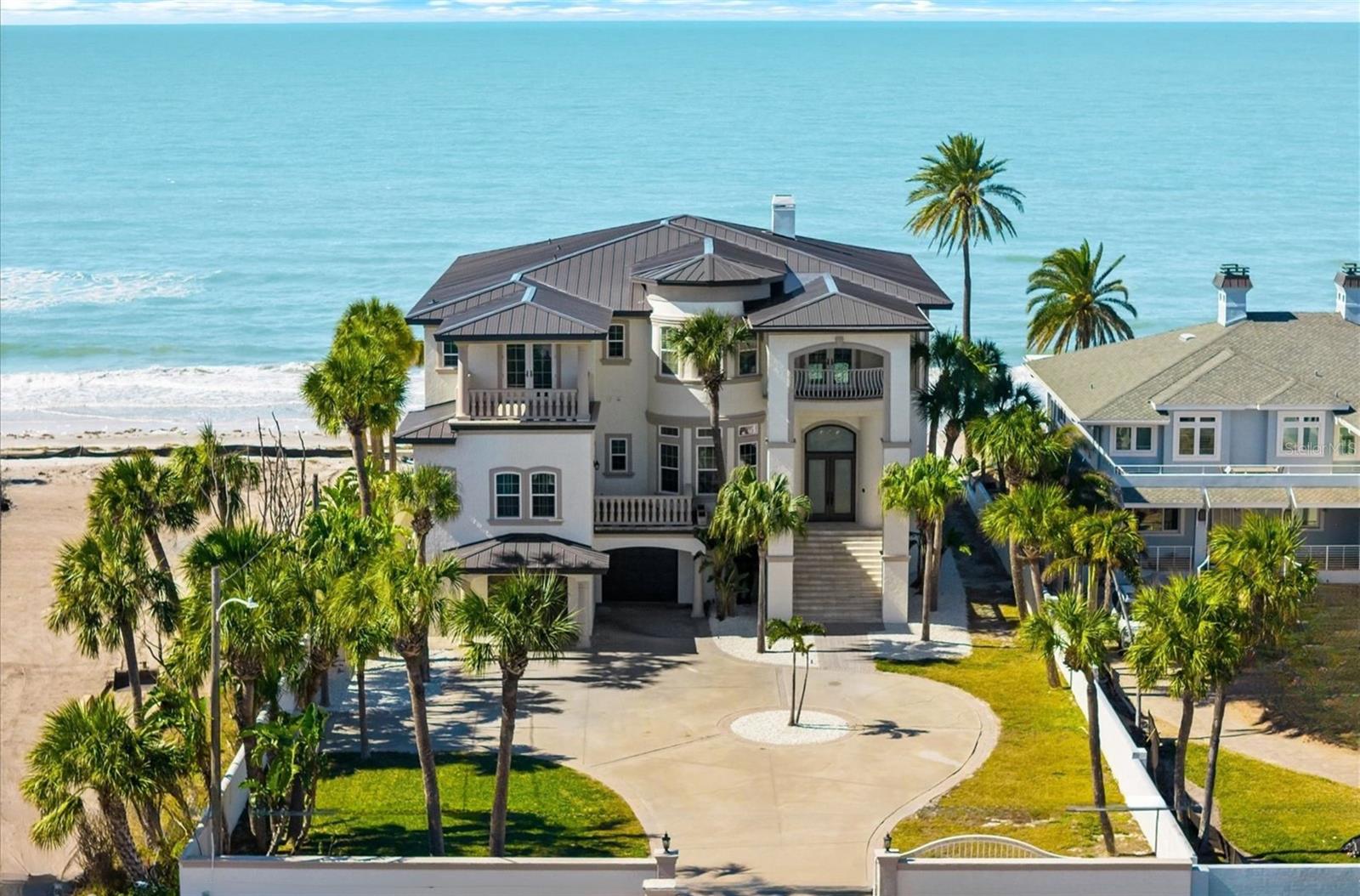 960 Gulf Boulevard is an exclusive Belleair Beach estate designed for both refined living and entertaining on Florida’s Gulf Coast. This three-story residence encompasses 7,528 square feet of living space, situated on a 0.44-acre lot with 80 feet of direct Gulf frontage. The home features five bedrooms, six full bathrooms, and two half-baths, providing spacious accommodations for family and guests. The primary suite on the third floor measures 21 by 18.5 feet, carpeted for comfort, and offers sweeping views of the Gulf. Secondary bedrooms are equally spacious and designed with functionality and comfort in mind.The interior is defined by high ceilings, crown molding, and two fireplaces in the living and family rooms. A fully equipped wet bar supports entertaining at any scale, and a private elevator ensures convenient access to all levels. Flooring throughout blends ceramic and quarry tile in main living areas with carpet in bedrooms, offering a thoughtful balance of durability and comfort.The chef’s kitchen includes premium appliances such as a cooktop, range, refrigerator, freezer, dishwasher, washer, dryer, and disposal. Its design ensures a seamless connection to dining and living spaces, allowing for both everyday use and large-scale entertaining.The exterior of the home is equally impressive, with a private in-ground pool, expansive balconies with panoramic Gulf views, and a concrete seawall providing security and uninterrupted water access. The block construction and tile roof combine durability with aesthetic appeal. Additional features include a two-car attached garage, no HOA or CDD fees, and lease options of one to two years, subject to city regulations.This estate provides an exceptional opportunity for buyers seeking a fully realized coastal residence with both functional and luxurious living spaces. 960 Gulf Boulevard offers direct Gulf access, high-end finishes throughout, and thoughtfully designed indoor and outdoor spaces, making it ideal for entertaining, private family living, or seasonal use. It represents one of the most distinguished offerings on the Belleair Beach waterfront, where privacy, elegance, and lifestyle converge at the highest level.