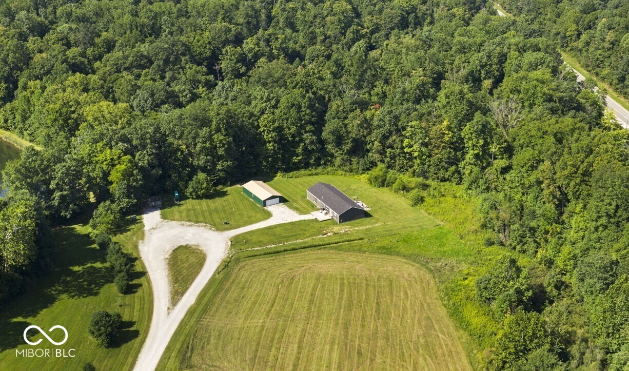 Your country estate awaits with this ranch home built in 2022 sitting on 14.21 wooded acres with an abundance of deer, turkey, mushrooms and wildlife of all kinds.  This one is truly a nature lover's dream come true!  You will love the 3 HUGE bedrooms that each have their own full bathroom!  (At 20x15, BR #2 is so large, it's like a second primary bedroom and could easily serve as an in-laws quarters.)  At 24x50, the 1,200 SF Pole Barn has all the room you need to park vehicles, have a workshop and/or the perfect storage space.  Spacious front deck and serene back patio overlooking the wooded acreage.  Great country location with easy access to I-70 for commuting.  Both a Living Room AND a Family Room.  Laundry Room with washer & dryer included and a handy Mud Room, as well.  The gourmet Kitchen is the heart of the open concept home with stainless steel appliances all included, hickory cabinets, tile backsplash, farmhouse sink, large corner walk-in pantry and huge center island/breakfast bar.  Split floorplan with the Primary BR on one side of the house and BRs #2 and #3 on the opposite side.  The Primary BR Suite features a large private bathroom with a massive oversized custom tile shower, double sinks and plenty of cabinet/vanity space.  You will also love the spacious walk-in closet. Connected to city water and city sewer.  Come and take a look before this one is GONE!!!