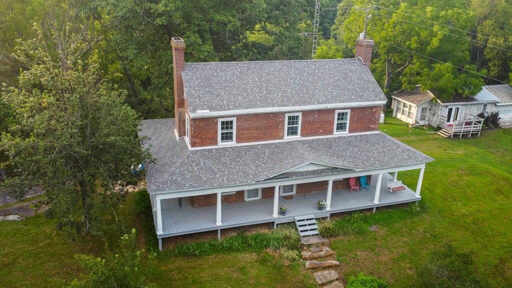 Here is a rare chance to own a true piece of Grayson County history. Built in the early 1830s, this home at 61 Caprine Lane is featured in Memories of Grayson County by Clevie H. Wingate and noted on old maps as the “Greek Post Office.” This 3-bedroom, 2-bath home with about 2,000 sq. ft. retains its historic character with fireplaces in many rooms (gas hookups ready), while the guest house features gas logs already installed.  The property also includes the original spring house, which still flows, though both the main home and guest house are serviced by a well. Thoughtful updates have ensured the home's comfort and preservation, including new windows (2015), a new roof with new plywood, all new insulation and drywall, updated electrical, fresh paint, and refinished polyurethane floors.  Set on 14 acres by boundary, this property is surrounded on three sides by Peach Bottom Creek, offering privacy, natural beauty, and abundant wildlife. Rolling fields and wooded areas create a peaceful setting, while the location is just minutes from the New River, the New River Trail, Galax, and Independence.  This historic homestead is a rare opportunity for anyone who values history, heritage, and the timeless beauty of the Virginia mountains.