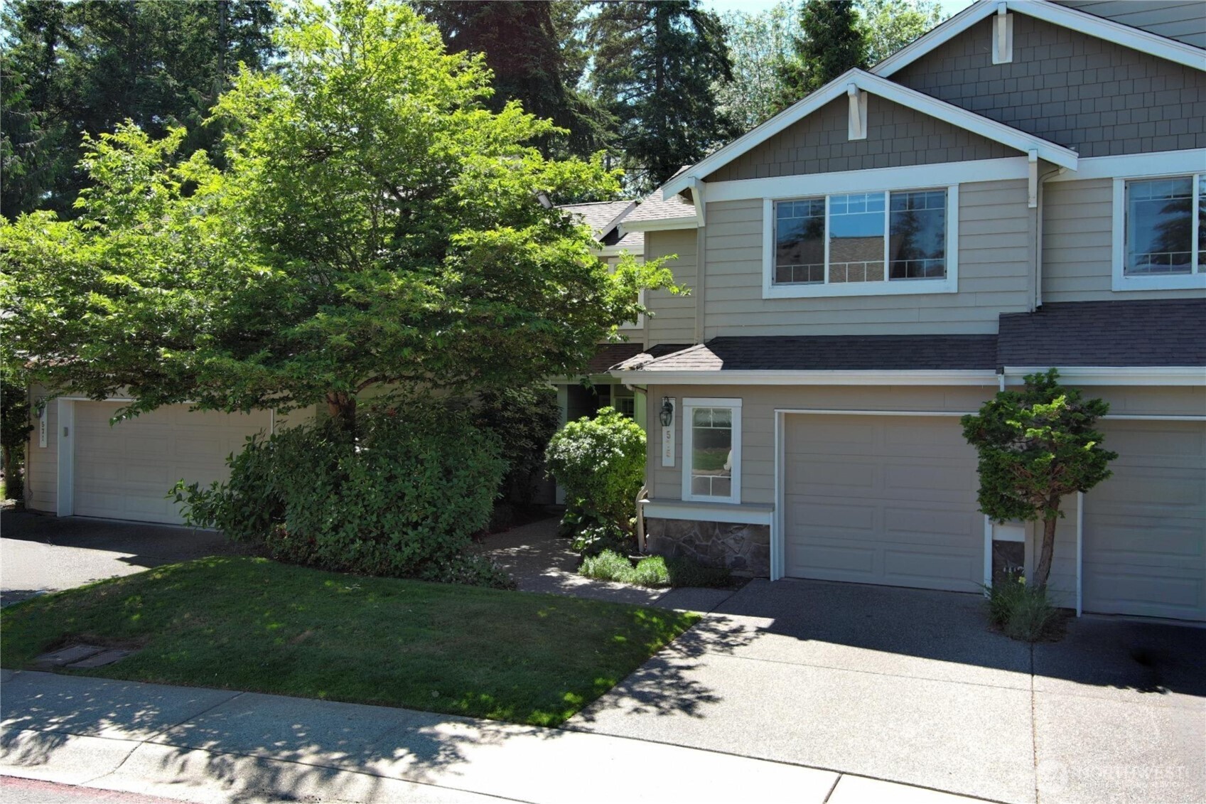 Welcome home to sophisticated, low-maintenance living at its absolute finest! Nestled in Blueberry Place—a premier gated community just 10 minutes from The Landing, Lake Washington, and major freeways—this bright, open-concept townhome is a total standout. Prepare to be wowed by soaring vaulted ceilings, dramatic windows flooding the space with natural light, and easy care hardwoods throughout the main level. The inviting living area, anchored by a cozy gas fireplace, flows effortlessly into the dining area and kitchen. Complete with new quartz countertops, a walk-in pantry, and a fantastic split-level peninsula. This layout is tailormade for entertaining! The main floor also features a versatile den/office or 3rd bedroom, plus a convenient half bath. Upstairs, luxury awaits with two generous primary suites featuring vaulted ceilings. The expansive main suite includes a 3/4 bath and a massive walk-in closet, while the second suite offers its own private full bath and peaceful views—perfect for guests. An upstairs laundry room serves both suites with ease. Step outside to your serene, private patio backing to a lush, greenbelt—a rare, peaceful retreat for your morning coffee or summer BBQs, and it is plumbed for gas! Finished with an attached, one-car garage with ample storage, this commuter’s dream puts groceries, coffee, dining, and transit just steps away. Come home to a life of ultimate comfort, absolute convenience, and carefree living!