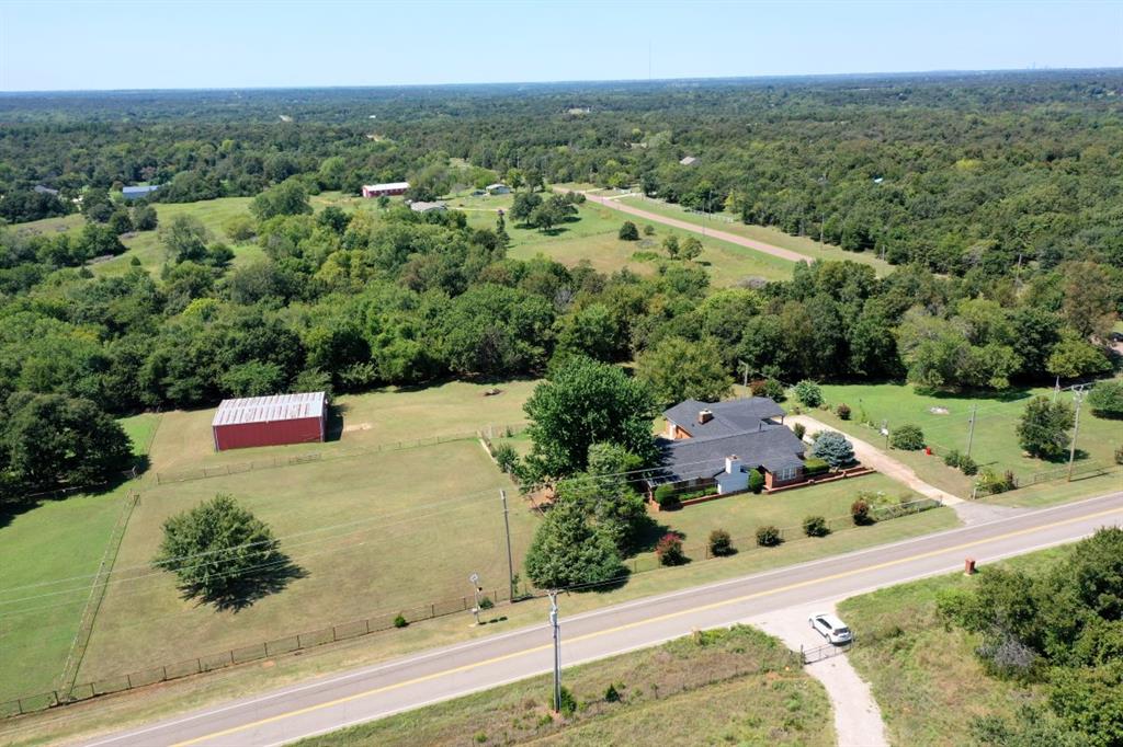 Country Living Awaits! 3 bedroom home in NE Norman on 5 acres MOL, fenced with a barn ready for new owners. Located on the SW corner of Tecumseh Rd and 108th Ave NE near Lakeview Elementary school. Barn with stalls and pipe fencing sectioned for livestock. Well maintained, landscaped and mowed acreage with wooded tree line to the west boundary of the property. 108th Ave on the East, Tecumseh Rd to the North and Lakeview Elementary school to the South. The home has NEWER HVAC system, PEX plumbing and Composition ROOF installed Spring 2025. 3 bedrooms 3 full bathrooms 2 living rooms (2 fireplaces) and 2 dining rooms with indoor utility room, attached two car garage and newly remodeled carport. So much space to occupy now or reconfigure to make it your own. Great bones and new mechanical systems allow the freedom to remodel and focus on the cosmetics of your personal preference. Minutes from Lake Thunderbird State Park yet still within the City limits of Norman OK. Peaceful setting with wildlife sharing the yard space morning and night.  OEC fiber internet available and City of Norman trash service, well water and septic system with OEC electric.