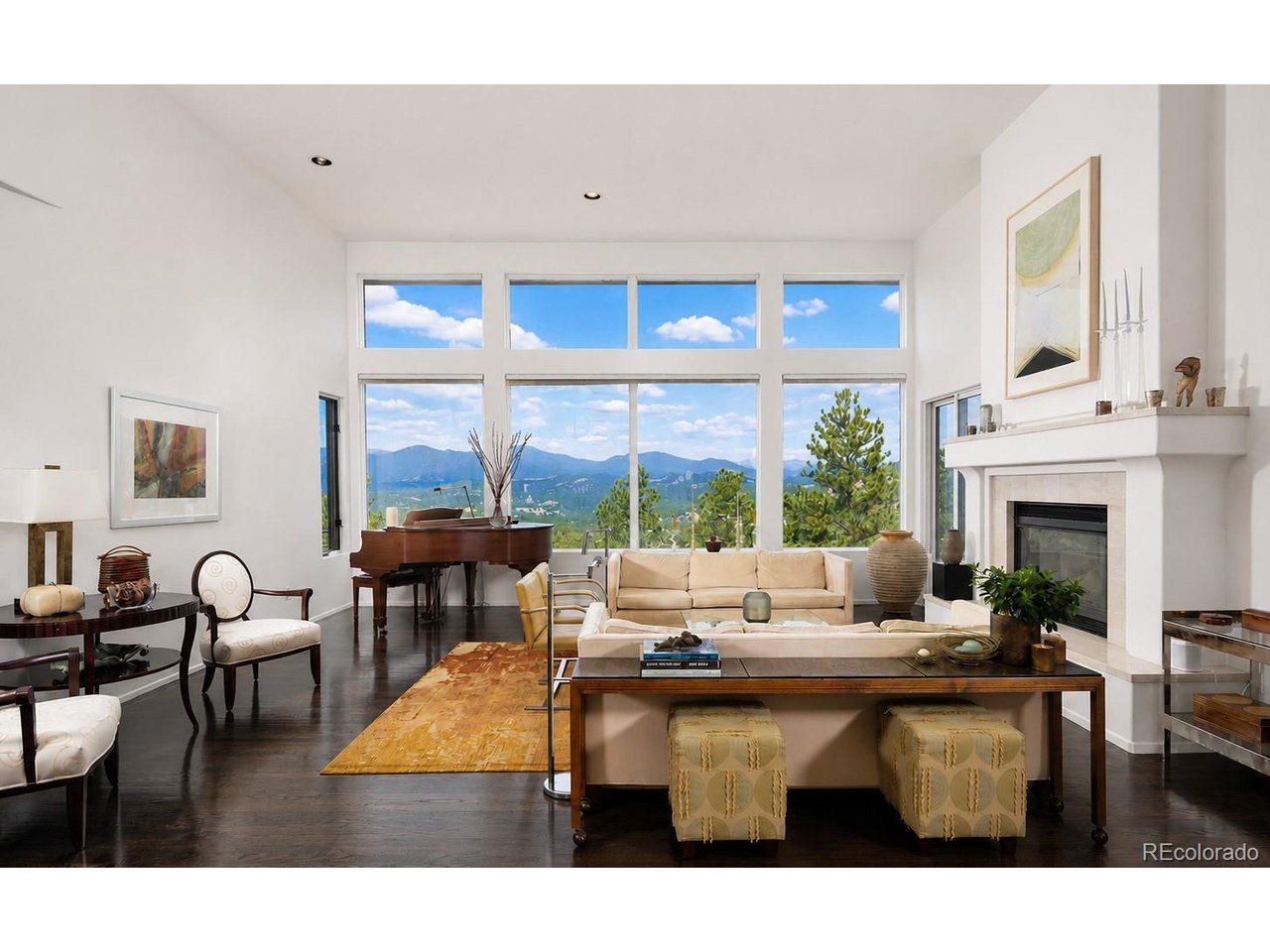 TWO ICONIC WHITE CAPPED MOUNTAIN VIEWS. MAIN-LEVEL LIVING. BACKING TO OPEN SPACE. From the moment you step inside, the setting is unforgettable. Sweeping views of Mount Blue Sky & the Arapahoe Peaks fill the great room, while walls of windows and direct access to the expansive deck create a seamless connection to the surrounding landscape. This is Colorado living at its best, where morning coffee comes with a mountain backdrop and evenings end with spectacular sunsets. The thoughtfully renovated kitchen pairs contemporary design with everyday functionality, featuring Miele appliances and sleek Leicht cabinetry. It flows effortlessly into the casual dining area & out to the deck, while a formal dining room provides an elegant setting for larger gatherings. A private home office overlooking the mountains makes working from home especially inspiring. The main-level primary suite is a true retreat, complete with beautiful views, a gas fireplace and deck access. The walkout lower level is designed for both entertaining and flexibility. A spacious family room with mountain views, gas fireplace and a wet bar with seating sets the stage for game days, movie nights and gatherings with friends. Two bedrooms, a full bath and laundry occupy one side, while the other offers a versatile flex room ideal for a fitness studio or nonconforming bedroom, an additional bedroom, a three-quarter bath and a private sauna. Outside, the property becomes its own Colorado retreat. Backing directly to open space, the outdoor living invites you to enjoy the setting throughout the seasons. A built-in pizza oven, hot tub and gently sloping yard create exceptional spaces to entertain, unwind and take in the natural beauty surrounding the home. Genesee is a foothills community offering 12 miles of hiking trails, 1,200 acres of open space, two pools, tennis and pickleball courts, a fitness center, a playground and vibrant community events, all just 30 minutes from Downtown Denver.