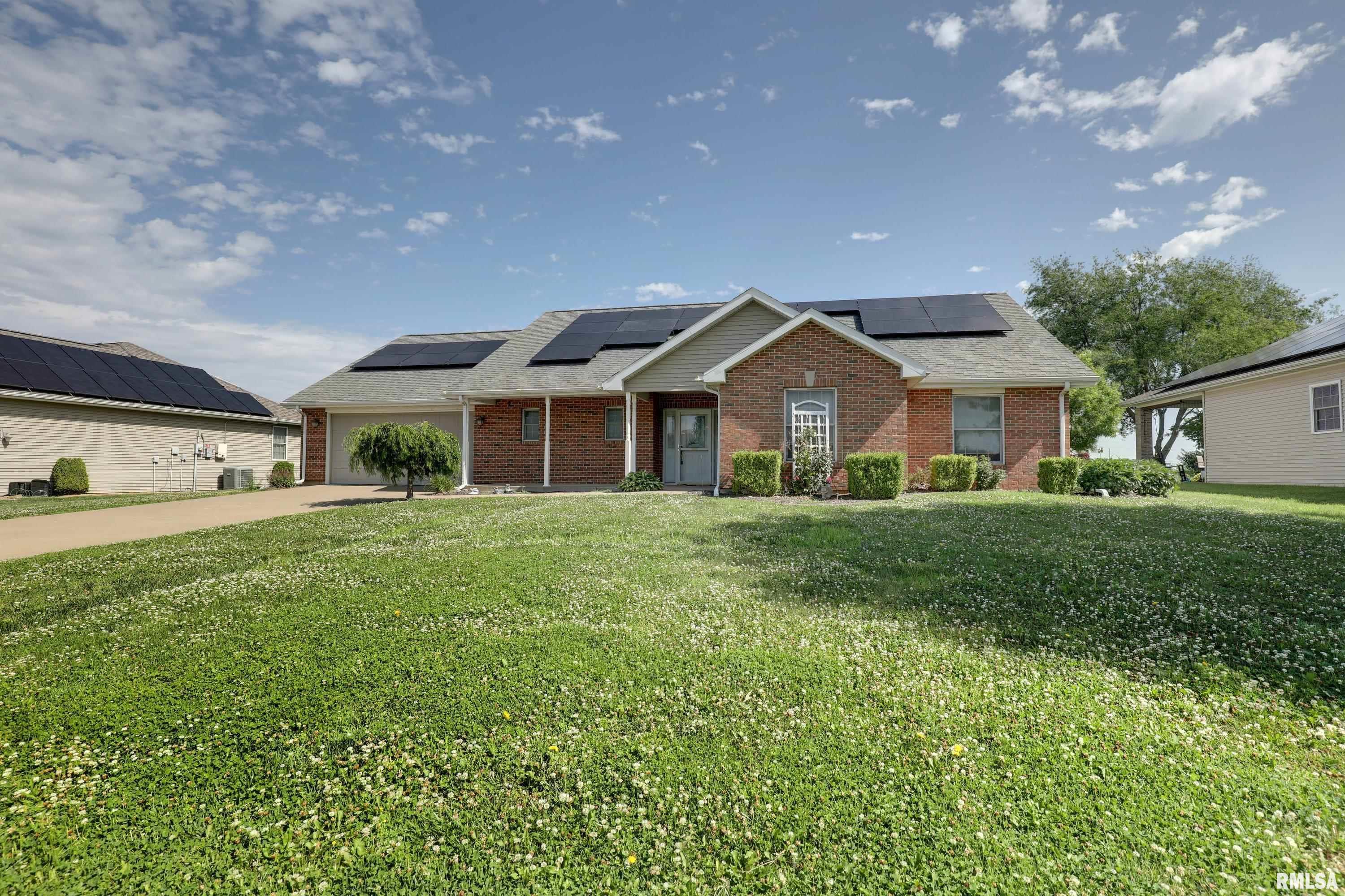Welcome home to effortless, single level living at its finest. Built in 2006, this beautifully designed 3-bedroom, 2-bath slab home offers the perfect blend of modern comfort and thoughtful accessibility. An ideal choice for those looking to downsize or embrace a worry-free retirement lifestyle!  From the moment you arrive, the zero-entry design sets the tone: no steps, no barriers, just seamless living from the garage to every corner of the home. The dramatic vaulted ceilings and a cozy fireplace make the living room feel both expansive and inviting. The eat in kitchen is well appointed with plenty of cabinet space.  The primary suite is a true retreat, featuring a luxurious soaking tub, a walk-in shower, and a generously sized walk-in closet. Two additional bedrooms and a full second bath offer flexibility for guests, a home office, or hobbies. Main floor laundry adds everyday convenience, while the three-season sunroom off the back provides the perfect spot to relax and enjoy the outdoors year-round.  Energy-conscious buyers will love the solar panels, paid off at closing, delivering long-term savings from day one. The attached two-car garage rounds out this exceptional home.  Everything you need, all on one level. This is the one.