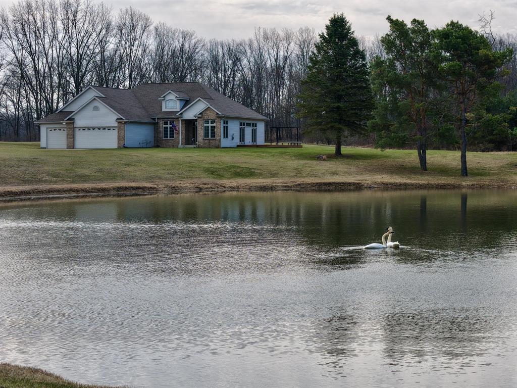 This one-owner, custom-built luxury ranch sits on almost 6 serene acres and offers breathtaking views of your own private pond. A long asphalt driveway guides you to a spacious four-car attached garage, ensuring both convenience and ample storage. The main level boasts a grand living room, a primary suite with a luxurious bath, and an additional main-floor bedroom with a full bath for flexible living. Downstairs you'll find two more generously sized bedrooms and another full bath, perfect for guests or a home gym. Step outside to a very large deck that provides ideal spaces for entertaining, relaxing, grilling and enjoying all the wildlife in and around the pond. Energy efficiency and reliability are top-of-mind with geothermal heating and a whole-home automatic generator, delivering comfort year-round and peace of mind. This thoughtfully designed layout combines single-level living with comfortable lower-level versatility, all in a private, scenic setting. Call Realtor Dustin Damon at269-317-0988. PLEASE REMOVE SHOES FOR SHOWINGS
