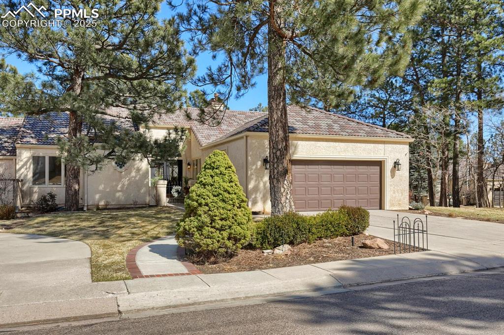 This townhome is in the sought-after Pine Terrace gated community. Built in 1984, this home underwent a full remodel in 2020. A heavy iron entry door opens to a warm and inviting great room featuring field-finished hardwood floors, a double-sided stone fireplace, and beamed vaulted ceilings.  On the opposite side of the fireplace is a relaxing hearth room, adjacent to the gourmet kitchen, featuring leathered granite, custom cabinets, a gas range, and upgraded stainless steel appliances. The primary suite opens to the back deck and features vaulted ceilings, a double vanity, a frameless shower, a built-in soaking tub, and two walk-in closets.  Rounding out the main level are a wine display wall, a custom powder room, a laundry room with pantry space, and a bank of windows overlooking the back deck.  The lower level features an open recreation room with a stone fireplace, a study, two additional bedrooms, and a fitness room.  This property is situated within minutes of the Broadmoor Hotel and Golf Club, Cheyenne Mountain Zoo, the Will Rogers Shrine, and extensive hiking and biking trails.