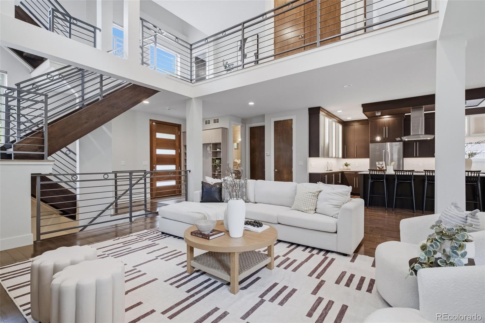 Exceptional contemporary living in the heart of LoHi, thoughtfully positioned off the street to provide a rare sense of privacy and tranquility while remaining just moments from the energy of one of Denver's most vibrant neighborhoods. This beautifully designed residence offers over 4,000 square feet of thoughtfully curated living space with five bedrooms, four bathrooms, and an ideal floor plan for both everyday living and entertaining. The light filled main level features soaring ceilings, wide-plank hardwood floors, and an open concept layout anchored by a chef's kitchen complete with premium Viking appliances, custom cabinetry, a generous center island, and seamless flow into the dining and living areas. Expansive glass doors create a seamless connection to the rare oversized backyard, extending the living space outdoors with room to entertain, garden, or simply unwind. The spacious primary suite serves as a private retreat with a luxurious five-piece bath, walk-in closet, and abundant natural light. Additional bedrooms offer flexibility for guests, family, or dedicated home office space. The finished lower level provides a spacious recreation room, additional bedrooms, and ample space for a home gym, media room, or other flexible living needs. An expansive rooftop deck showcases stunning city and mountain views, creating the perfect setting for morning coffee, evening sunsets, or entertaining under the Colorado sky. A brand-new roof adds lasting value and peace of mind for the next owner. Completing the home is an oversized two-car garage, offering exceptional space for vehicles, outdoor gear, and additional storage, an increasingly rare amenity in LoHi. Ideally located just blocks from LoHi's acclaimed restaurants, coffee shops, breweries, boutiques, neighborhood parks, and downtown Denver, this home offers the best of urban living while providing the space, privacy, and convenience that are seldom found in one of Denver's most sought-after neighborhoods.
