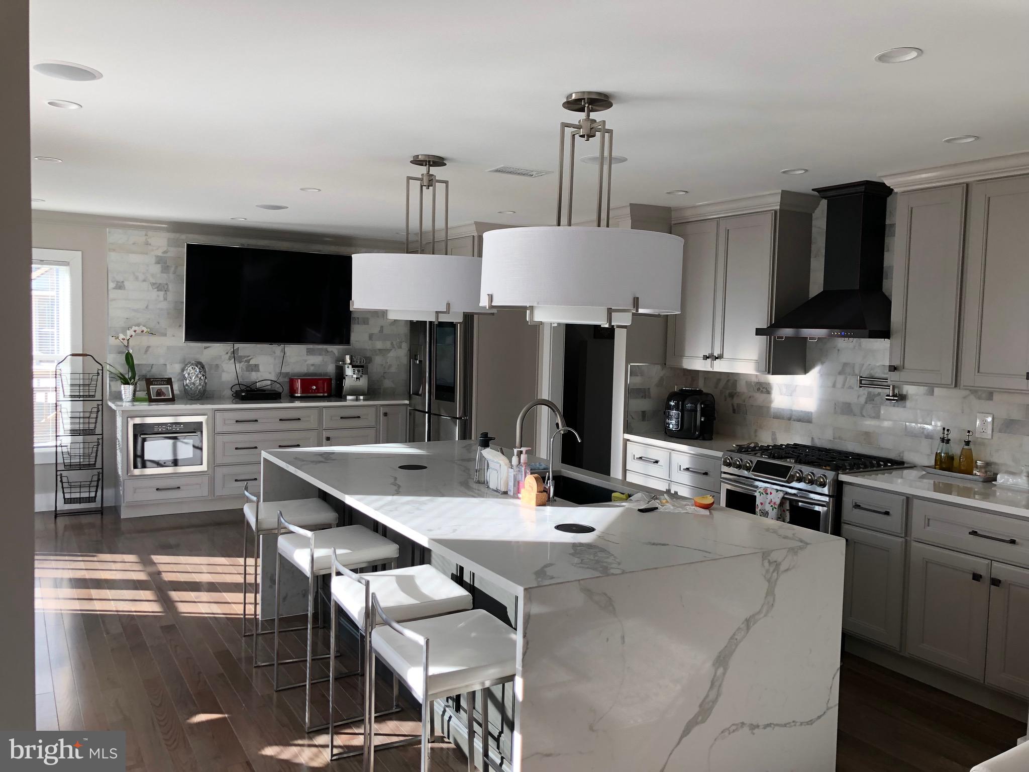 Completely remodeled in 2018, including new roof, windows, hvac and water heater.  This stunning home offers luxury, comfort, and exceptional indoor-outdoor living. The spacious open-concept kitchen is filled with natural light and features elegant quartz and marble finishes, perfect for entertaining and everyday living. The fully finished basement includes a second kitchen, a full bathroom, and an extra bedroom with a built in queen bed, providing ideal space for guests, extended family, or additional entertainment. The luxurious primary bathroom showcases marble and quartz throughout, along with a relaxing jet tub spa experience. Hardwood flooring runs throughout the entire home, complemented by generously sized bedrooms and built-in sound systems throughout the entire house. This home also comes equipped with fully paid-off solar panels, offering energy efficiency and long-term savings.  Step outside into your own private retreat backyard oasis featuring a custom wraparound deck surrounding the above-ground heated pool, a beautiful gazebo complete with a gas grill, sink, and mini refrigerator, plus a built-in gas fire pit perfect for gatherings year-round and plenty of storage including two sheds. Sports enthusiasts will love the custom basketball court with a professional adjustable hoop. A truly one-of-a-kind property combining luxury upgrades, entertainment, and modern convenience. Agent is the owner.