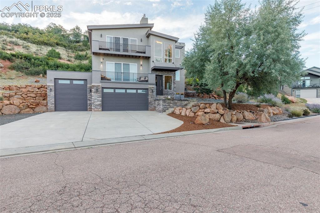 Welcome to an exquisite contemporary residence nestled in an exclusive enclave, where the natural beauty of Red Rocks Open Space unfolds right outside your door. This custom-built masterpiece boasts high-end finishes and elegant details throughout. The main level, designed with a seamless open-concept layout, features a sophisticated living room with a gas fireplace and 12-foot sliding glass doors that invite you to step onto the view deck. The chef’s kitchen is exceptional, offering every luxury you could desire. Imagine hosting lavish gatherings around the kitchen island, while savoring the breathtaking views from the walkout deck. Ascend the stairs or glide up in your private elevator to your personal sanctuary. Here, the primary suite awaits, a tranquil haven with a gas fireplace, another 12-foot sliding door leading to a private deck overlooking the open space, and a spa-like ensuite bathroom. Indulge in the jetted tub or  multi-jet shower. The custom-designed walk-in closet ensures your wardrobe is impeccably organized, while the adjacent laundry room offers ultimate convenience. The upper level includes a versatile flex space with windows framing awe-inspiring views that can be used for a home office, library, or gym. The lower level offers two generous guest bedrooms and a full bath. A thoughtfully designed dog wash station, located just inside the oversized three-car garage, ensures your pets are pampered after exploring the nearby trails. The garage features an RV bay and an oversized two car garage. This prime location offers effortless access to Hwy 24, making Colorado mountain weekend trips a breeze, while being just minutes away from the dining and shopping experiences of historic Manitou Springs, Downtown Colorado Springs and Old Colorado City.  Included with this exceptional home are architectural plans for a 2500 sf addition featuring a luxurious spa area, exercise room, outdoor kennel area and guest suite with view deck and private entrance.