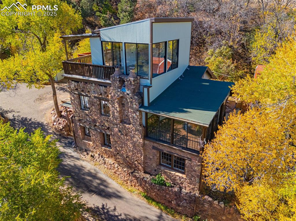 Historic charm meets modern mountain living at 10 Rock Hill Avenue — a completely reimagined home perched above iconic Manitou Springs with sweeping views of the mountains and downtown below. This storybook treehouse retreat blends century-old character with contemporary elegance, featuring timeless restored woodwork, exposed beams, and expansive view windows that fill the home with natural light framed by the trees, giving you the best seat in town to watch the sunrise over the mountains..Enjoy a stunning custom kitchen with quartz counters and designer finishes, beautifully updated baths, and open living spaces, enhanced by a large deck overlooking the trees and mountain peaks beyond. Recent upgrades provide exceptional value, comfort, style and peace of mind.Whether you’re seeking a full-time residence or a peaceful mountain getaway, this rare Manitou gem offers a one-of-a-kind blend of history, nature, and modern design — all just minutes from shops, restaurants, and hiking trails.