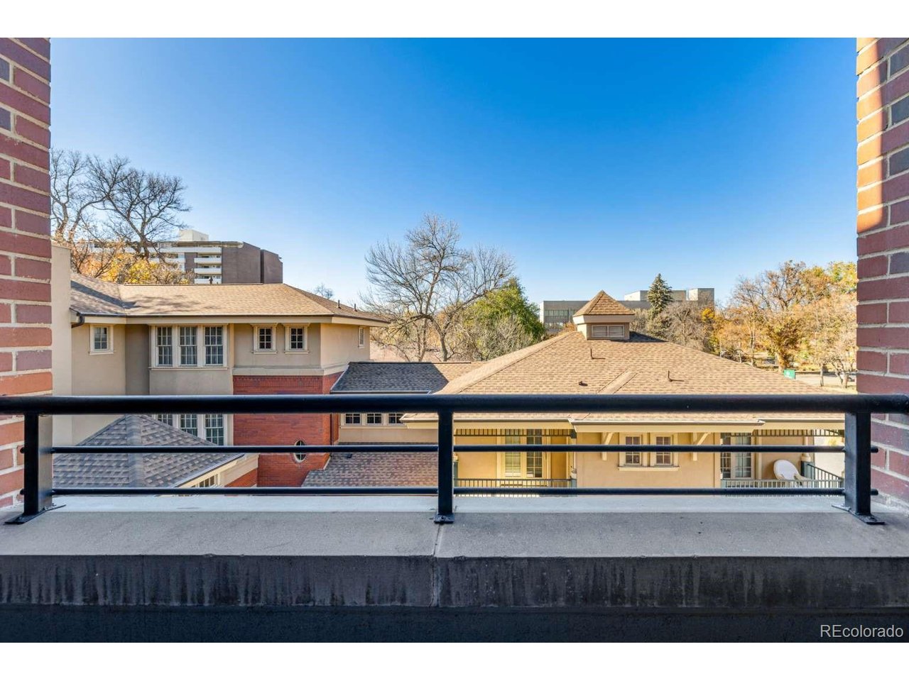 Experience urban luxury in this exceptional, turnkey loft on the 3rd floor of the prestigious Magnolia Lofts Building in Old Town Fort Collins. This residence seamlessly blends modern industrial elegance with top-tier sophistication. Step through 8-foot doors into an airy sanctuary featuring soaring 12-foot ceilings, floor-to-ceiling windows, exposed brick, and gleaming hardwood floors. The epicurean kitchen showcases a granite island with a breakfast bar, custom cabinetry, a professional gas range with a designer hood, and premium stainless steel appliances. The primary suite serves as a private retreat behind sliding pocket doors, offering a spa bath with an expansive multi-fixture shower, freestanding tub, large walk-in closet, and private laundry. A custom sofa with queen memory foam pull-out provides flexible guest space which can be separated from the primary suite. Enjoy sunsets from your private west-facing deck, or take in panoramic mountain views from the expansive community rooftop. Includes secured garage parking, elevator access, meeting rooms, and a new roof (2025). Steps from fine dining, shopping, the Lincoln Center, and CSU. An unmatched lifestyle opportunity.