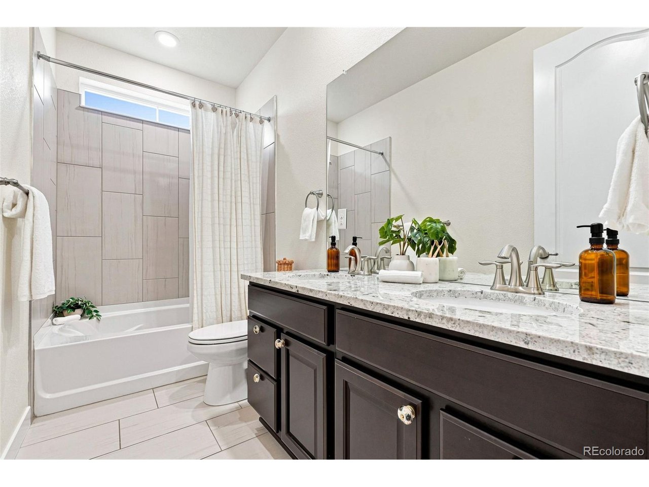 Perfectly positioned on a beautifully landscaped 9,100-square-foot lot backing to open space and neighborhood parkland, this exceptionally maintained home offers the privacy, views, and lifestyle that make Candelas one of Arvada's most desirable communities. Designed for today's lifestyle, the home features three bedrooms, three baths, and a dedicated home office all on the main level, plus a finished walkout basement with a fourth bedroom and bath, offering flexibility for guests or everyday living.Designed to embrace Colorado's indoor-outdoor lifestyle, the upper deck, covered walkout patio, welcoming front porch, and low-maintenance turfed backyard create inviting spaces to relax or entertain while enjoying peaceful open-space views. Large windows throughout fill the home with natural light.The open floor plan centers around a spacious kitchen with GE appliances, double ovens, a gas cooktop, oversized island, and generous pantry, all flowing seamlessly into the dining area and living room with a cozy gas fireplace. Brand-new carpet throughout the main-level bedrooms enhances the move-in-ready appeal. The primary suite features dual vanities, a spacious walk-in shower, walk-in closet, and direct access to the laundry room.A sun-filled office with direct access to the upper deck creates an ideal work-from-home retreat. The finished walkout basement expands the living space with a spacious media and rec room featuring a wet bar and bar fridge, plus abundant storage. And an oversized extra-deep garage offers amble space for tandem parking, a workshop, hobbies or outdoor gear.Enjoy the lifestyle Candelas is known for, with resort-style pools, fitness centers, parks, playgrounds, top rated schools and miles of scenic trails just moments from home. Ideally located with easy access to Boulder, Downtown Denver, and the foothills, this exceptional home offers the perfect balance of outdoor adventure, everyday convenience, and connected Colorado living.